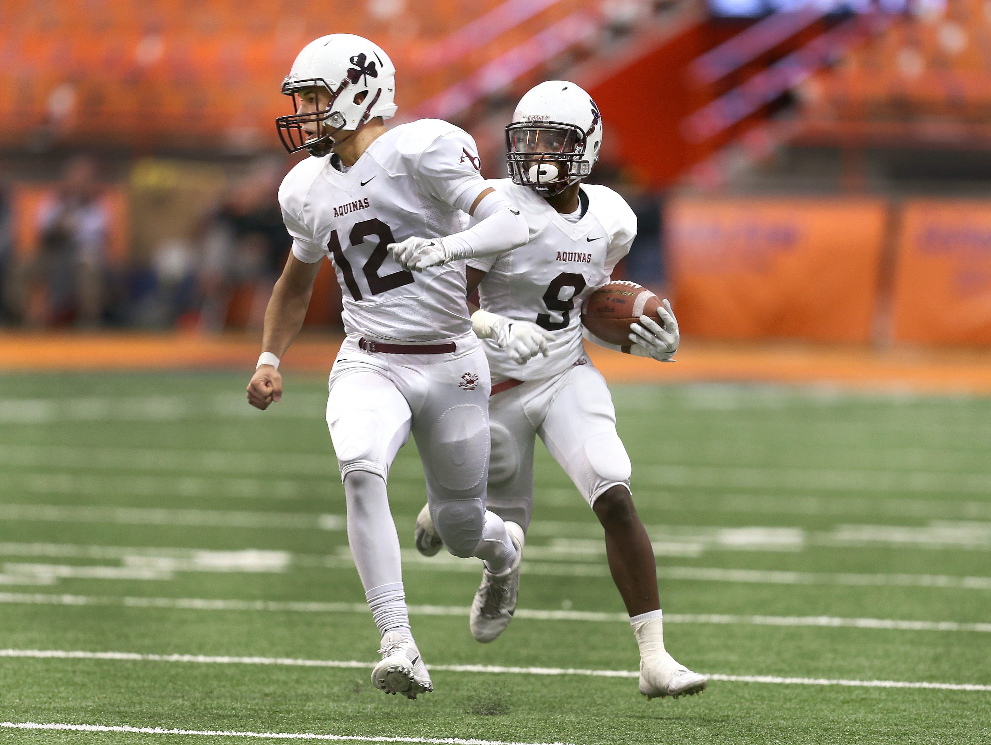 Aquinas quarterback Jake Zembiec (12) looks to block after receiver Earnest Edwards reversed direction after a catch. Aquinas beat Saratoga Springs 44-19 to win the State Class AA title.
