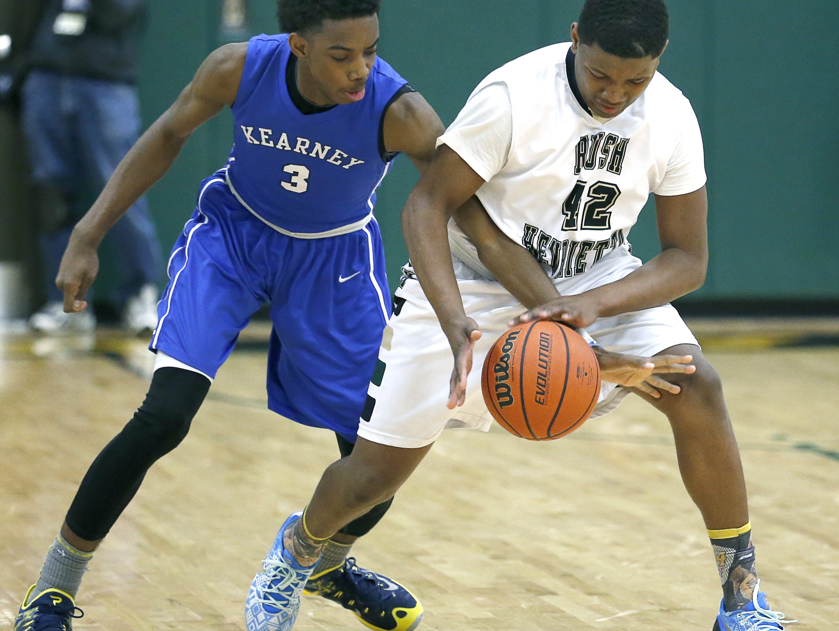 Bishop Kearney's Quinton Rose reaches for the ball as Rush-Henrietta's Ja'Shaun Smith dribbles in the third quarter at Rush-Henrietta High School.