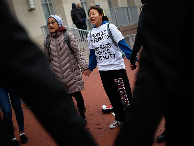 WASHINGTON, DC - NOVEMBER 25:  Protesters hold hands