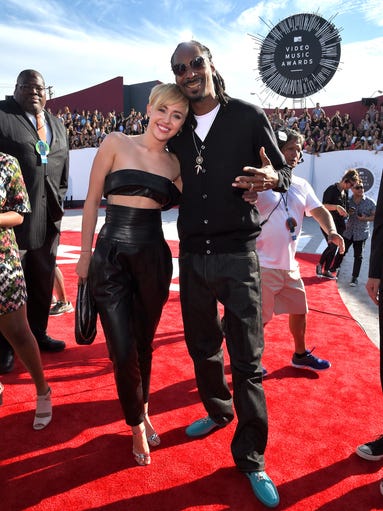 Singer Miley Cyrus (L) and rapper Snoop Dogg attend the 2014 MTV Video Music Awards at The Forum on August 24, 2014 in Inglewood, California.
