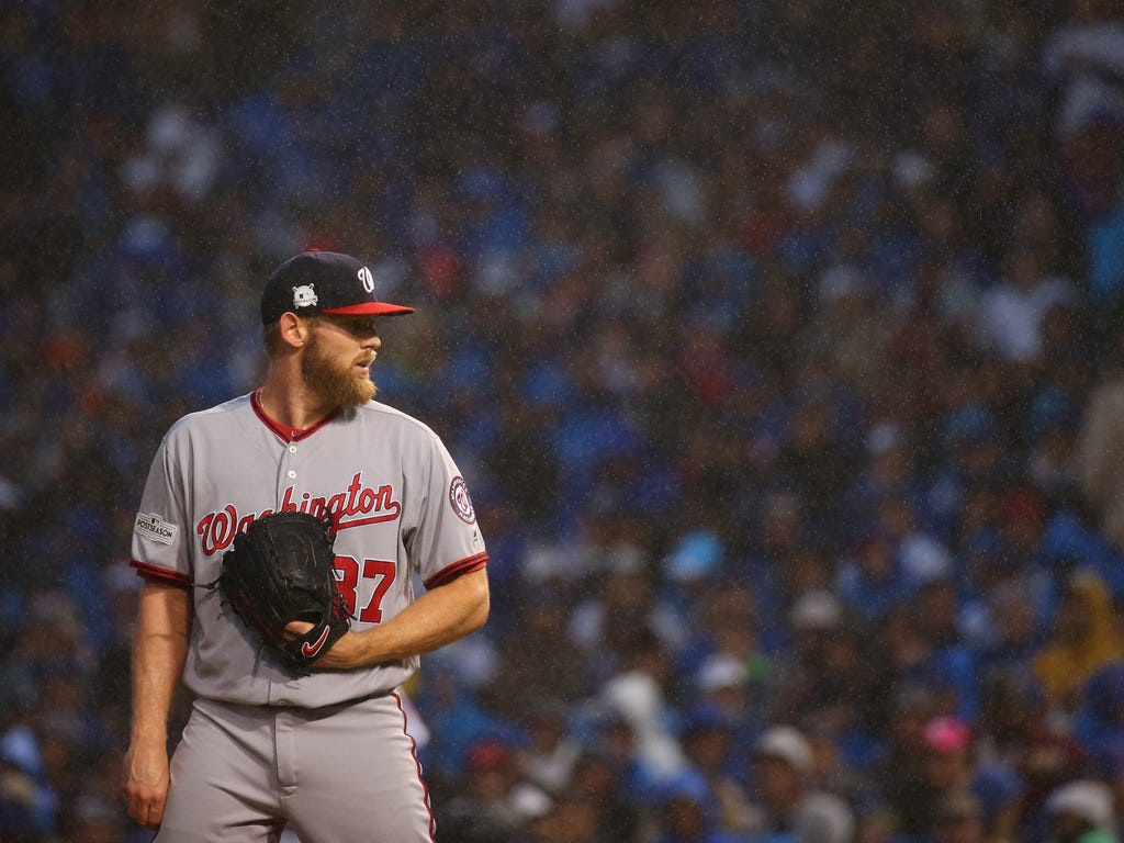 Washington Nationals starting pitcher Stephen Strasburg looks on while it rains during the seventh inning of game four of the 2017 NLDS playoff baseball series against the Chicago Cubs at Wrigley Field.