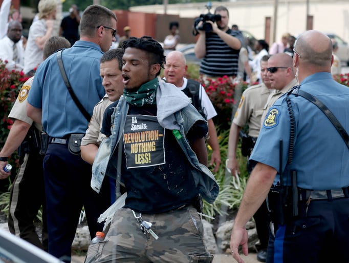 Police arrest a demonstrator protesting the shooting death of Michael Brown in Ferguson, Mo.