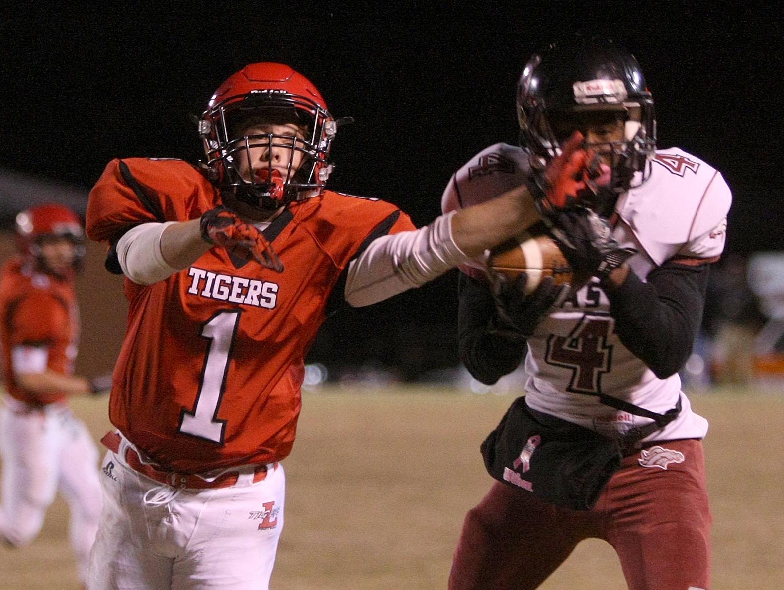 Lexington's Tucker White (1) tries to break up the pass to Memphis East's Terreyo Nailor (4) at Tiger Stadium on Friday.
