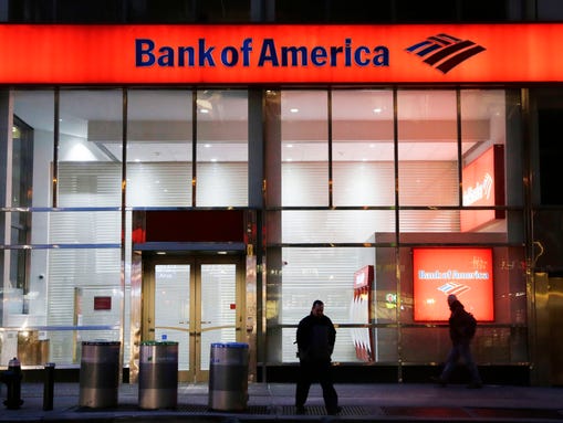 People walk past a branch of Bank of America, in New
