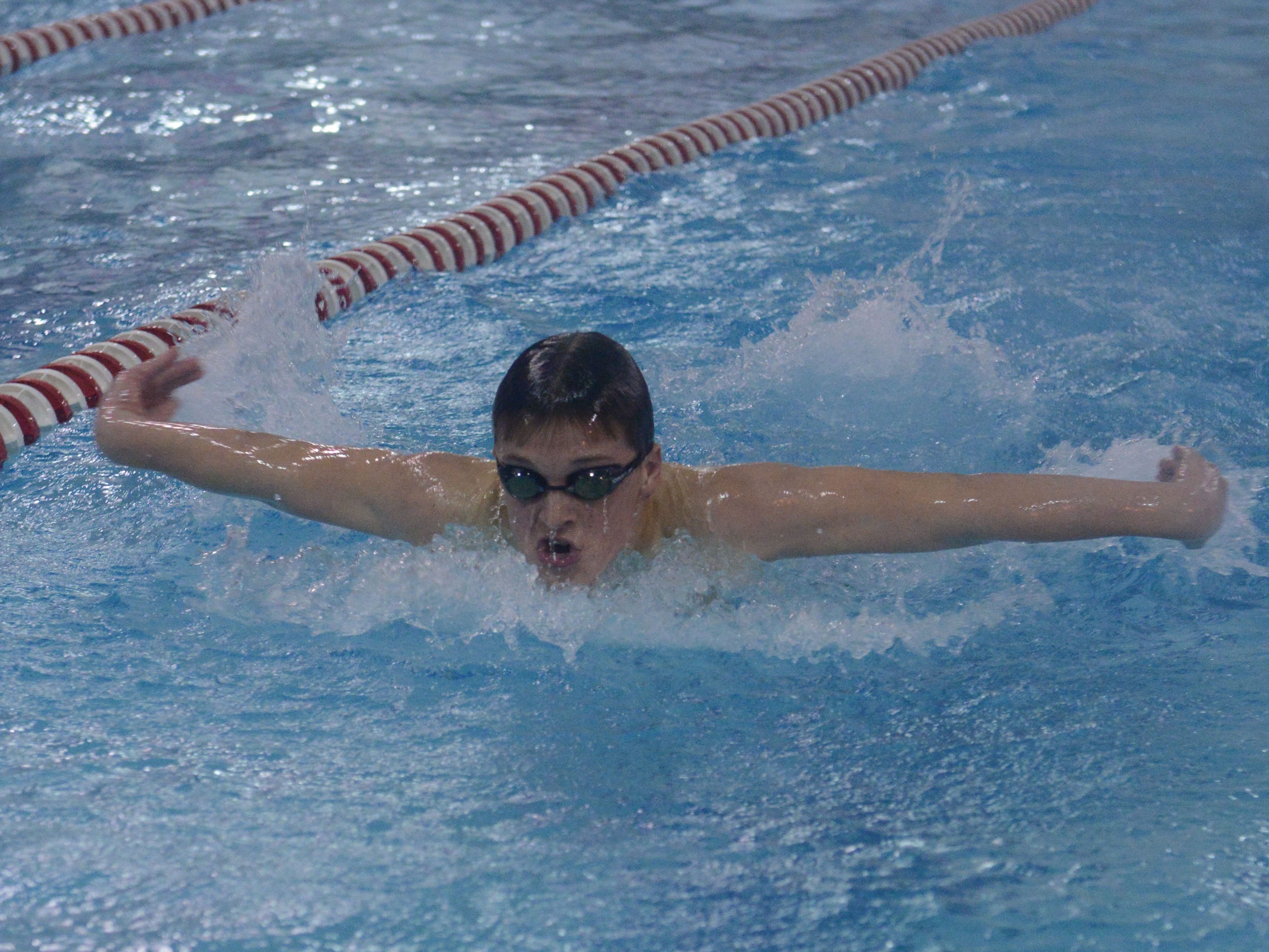 Fremont's Will Taylor competes in the 100 yard butterfly during a swim meet against Port Clinton on Thursday, Dec 18, 2014.
