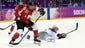 Canada forward Hayley Wickenheiser (22) clears the puck away from USA forward Alex Carpenter (25).