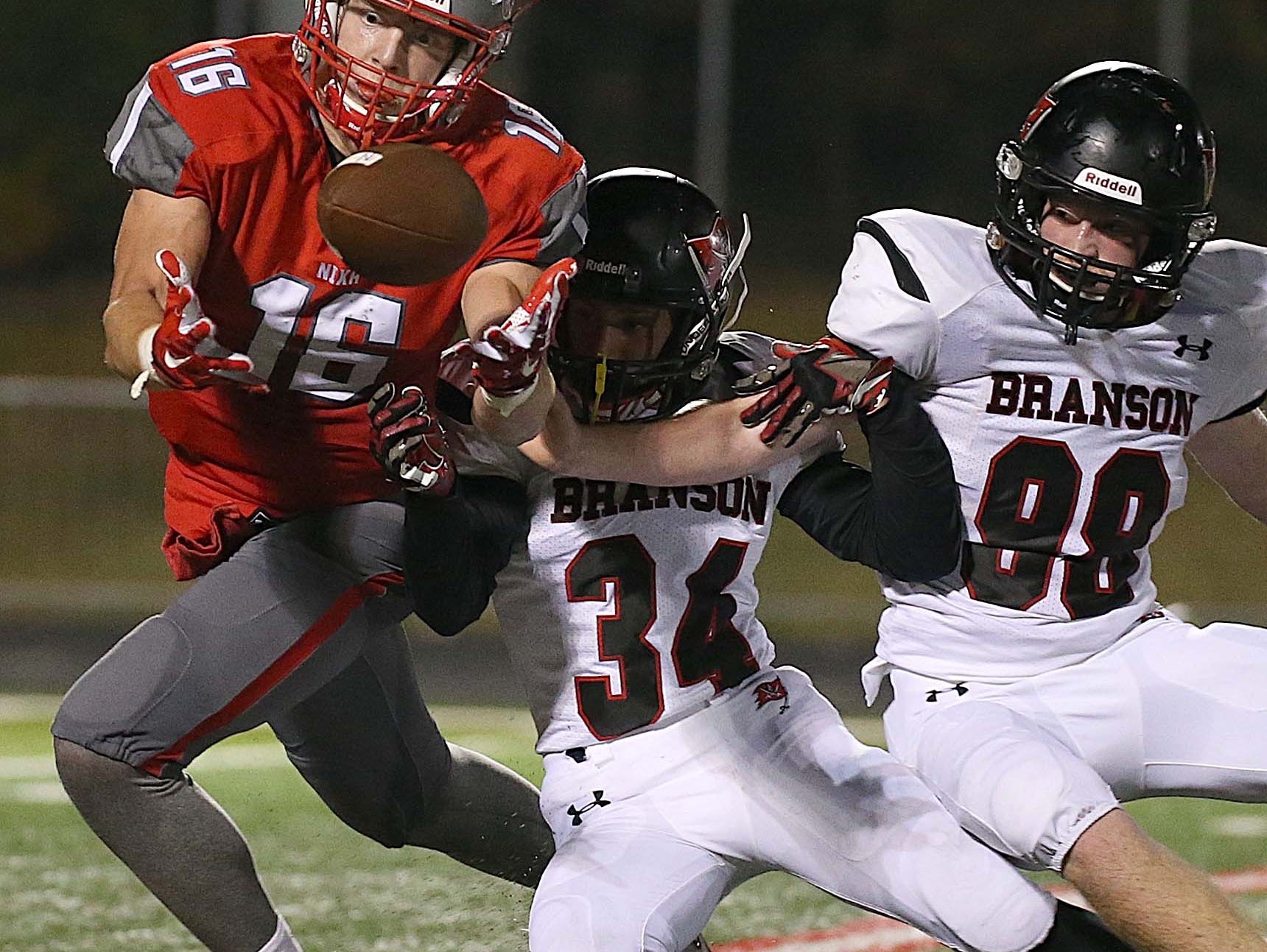 Nixa's Chase Allen makes a catch for a first down against Kyle Hunn (34) and Nathan Piche (98) of visiting Branson on October 23, 2015.