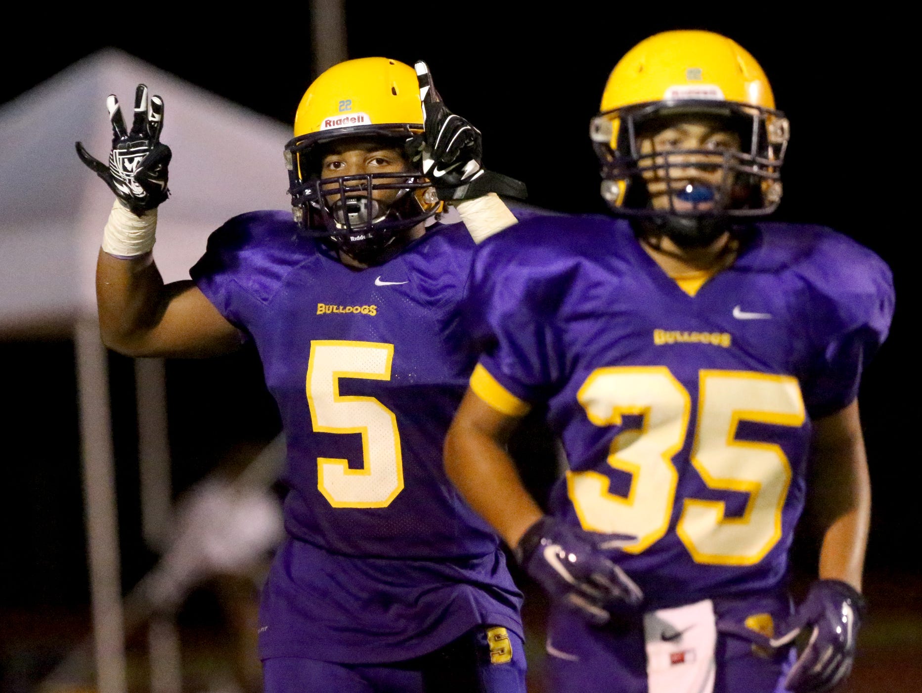 After scoring Smyrna's fourth touchdown against Siegel, Smyrna's Casey Perkins (5) holds up a 31 for injured teammate Deven Sims (31), who was taken to the hospital by ambulance earlier in the game against Siegel at Smyrna, on Friday Sept. 25, 2015. Smyrna teamate Blake Watkins (35) comes off the field with Perkins.