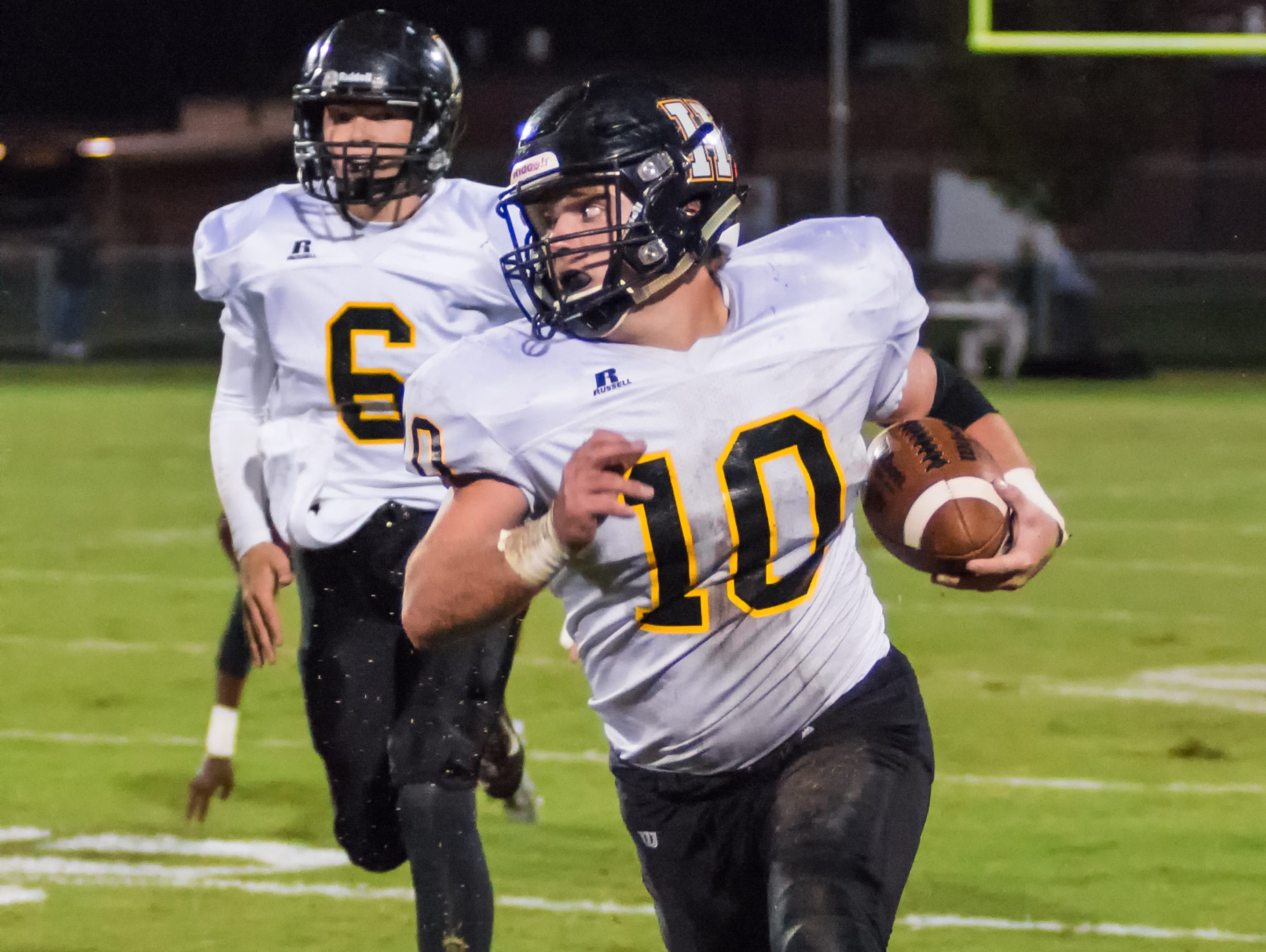 Hendersonville High senior Jack Towe carries the ball upfield as sophomore quarterback Brett Coker follows the play during Friday's contest.