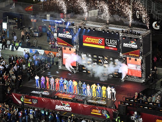 The drivers stand on stage as fireworks erupt during