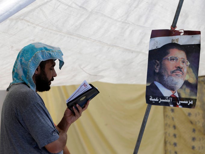 A supporter of ousted Egyptian president Mohammed Morsi reads the Quran on July 12 in Cairo's Nasr City district.
