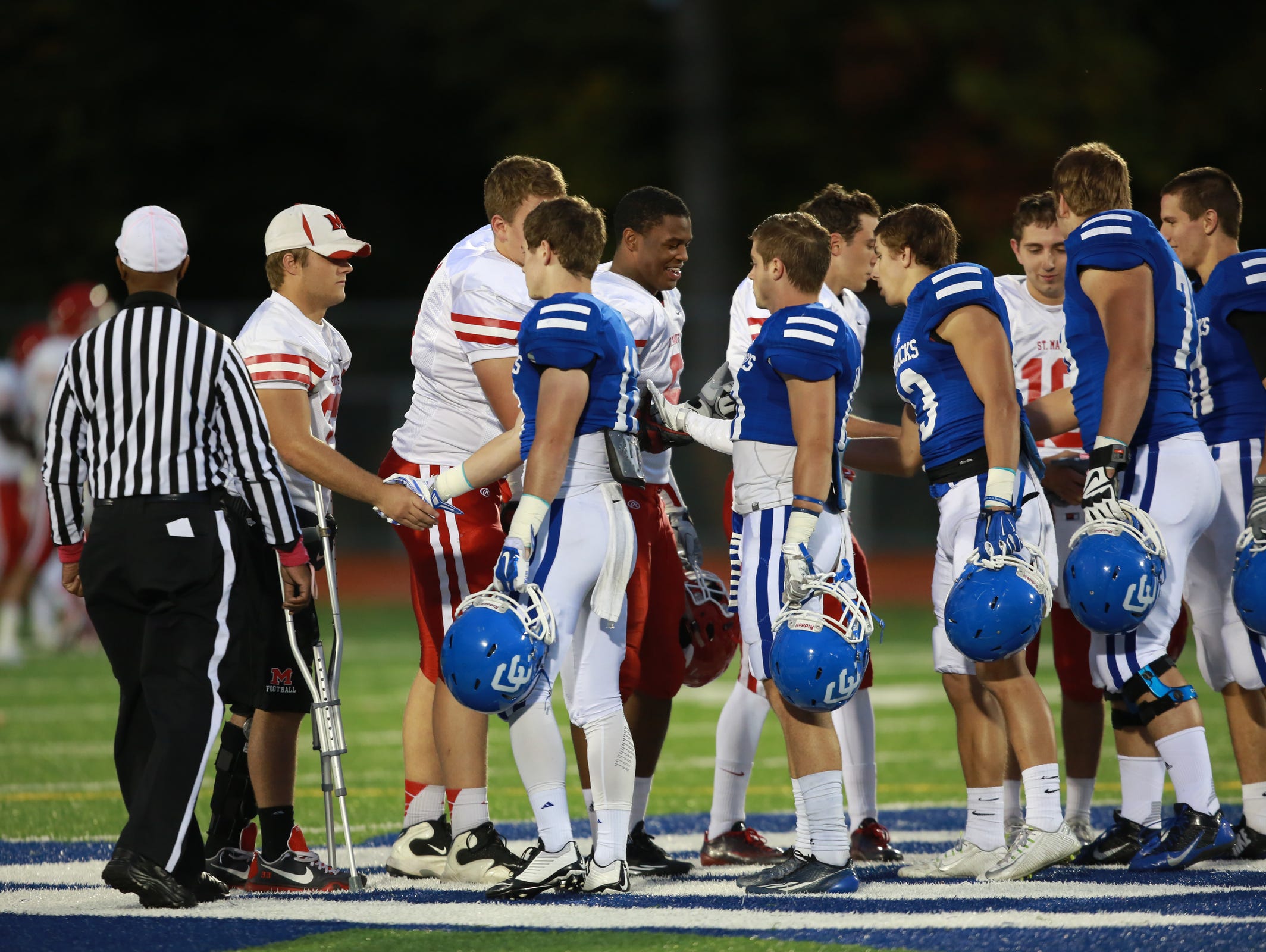 Orchard Lake St. Mary's at Novi Detroit Catholic Central shake hands before the start of their game in Novi, Mich. on Friday, Oct. 9, 2015.