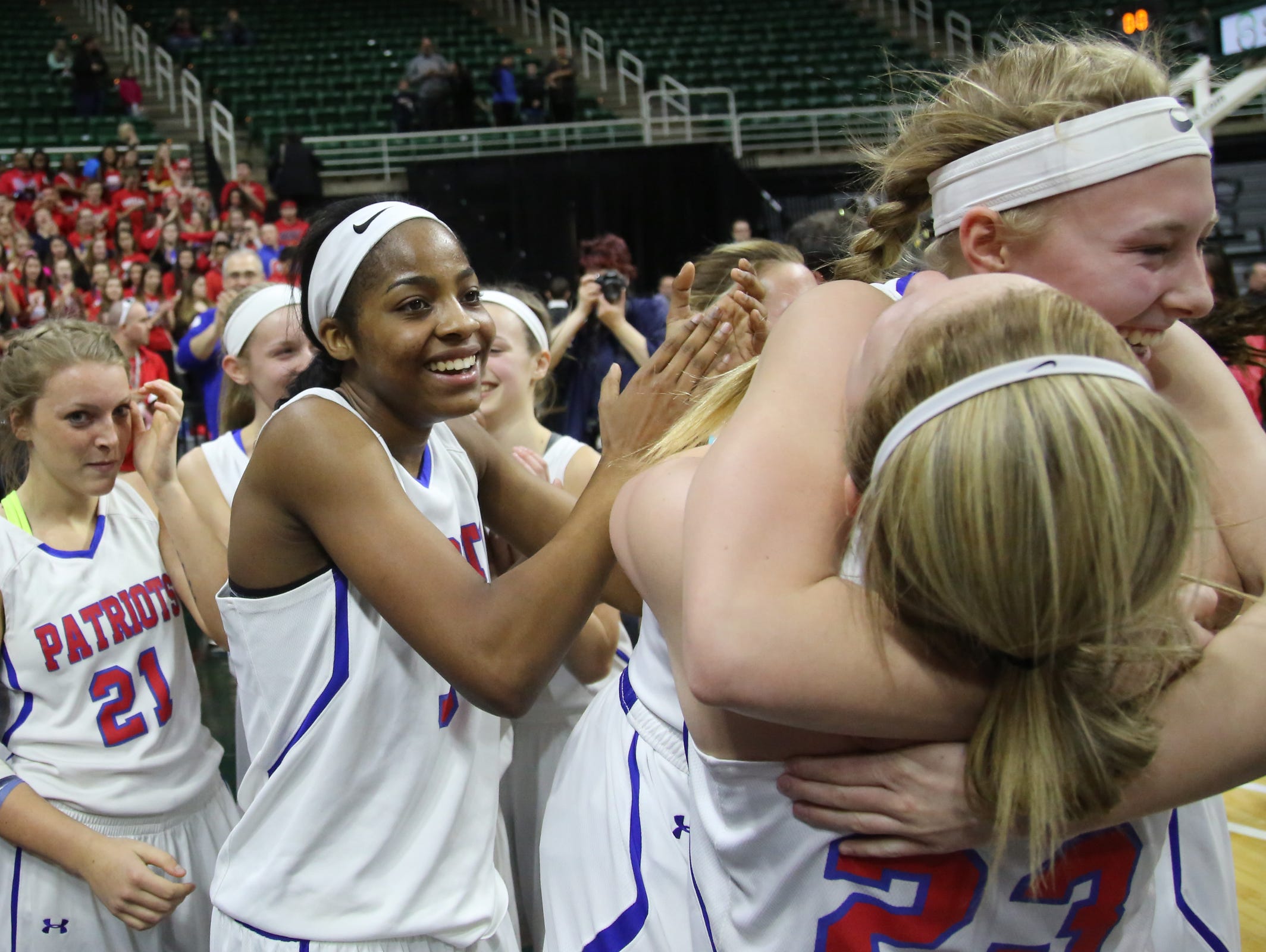 Warren Cousino's Aubrey Holman, Kierra Fletcher, and teammates celebrate defeating Hudsonville 60-45, during the MHSAA girls basketball Class A game 2 semifinals at the Breslin Center in East Lansing, Mich. on Friday, March 18, 2016.