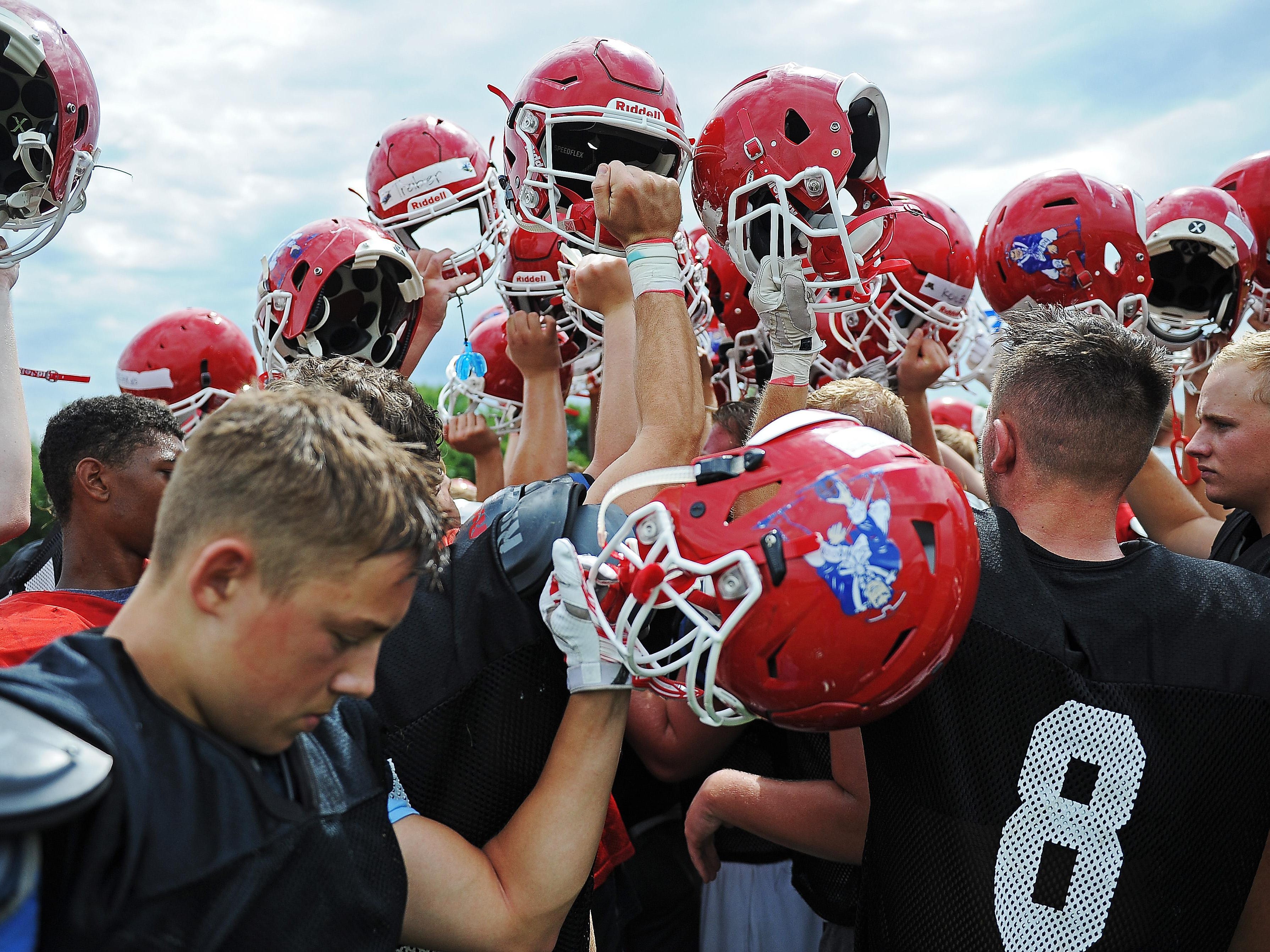Lincoln High School football players huddle together at the end of a Lincoln High School football practice Thursday, Aug. 11, 2016, at Lincoln High School in Sioux Falls.