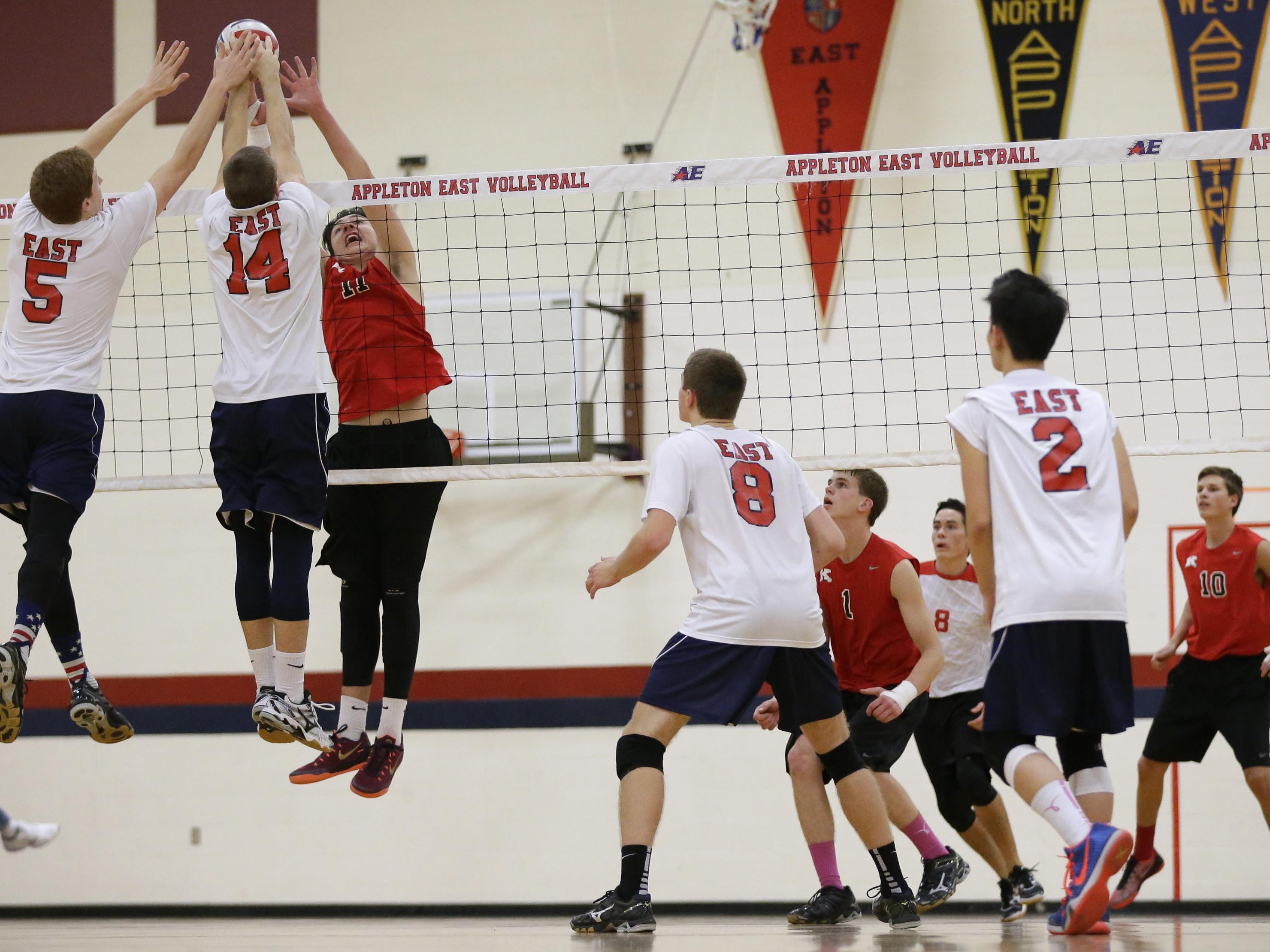 Appleton East High School's Matt Polfuss (5) and Blair Murphy (14) block against Kimberly High School's Michael Cartwright (11) during their volleyball match Tuesday, October 27, 2015, in Appleton, Wis. Dan Powers/Post-Crescent Media