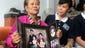 A mother displays a portrait of her son, Sugianto Lo, and his wife, Vinny Chynthya, who are passengers aboard the missing Malaysia Airlines flight in Medan on Sumatra island, Indonesia.