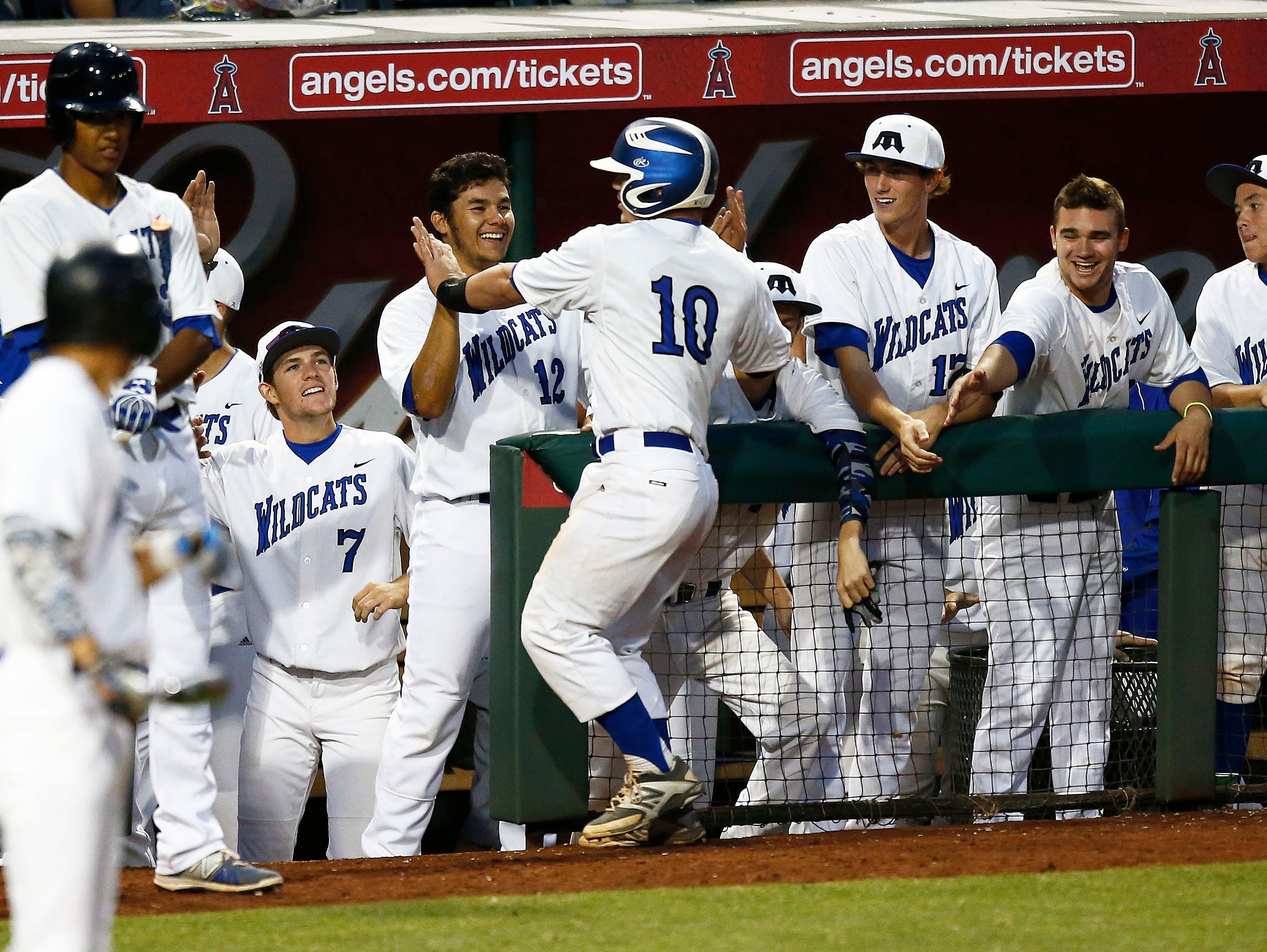 Brit Fitzgerald (10) of Gilbert Mesquite receives high-fives after hitting an RBI double against Glendale Mountain Ridge in the foiurth inning during the Division I state baseball semifinals on Thursday, May 14, 2015, at Tempe Diablo Stadium.