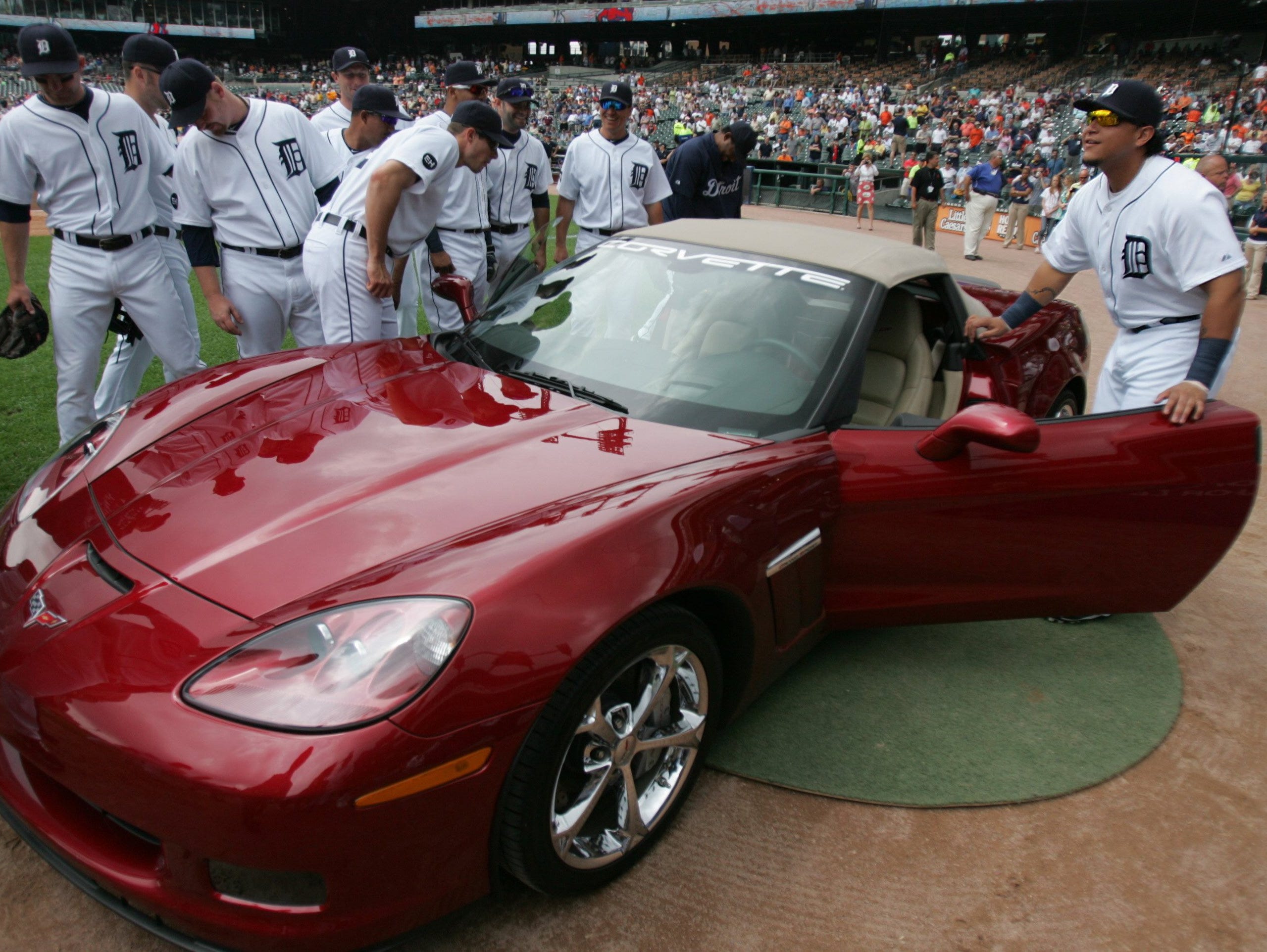 Detroit Tiger players check  out the new red Chevrolet Corvette given to Armando Galarraga by General Motors before a Detroit Tigers  game in 2010
