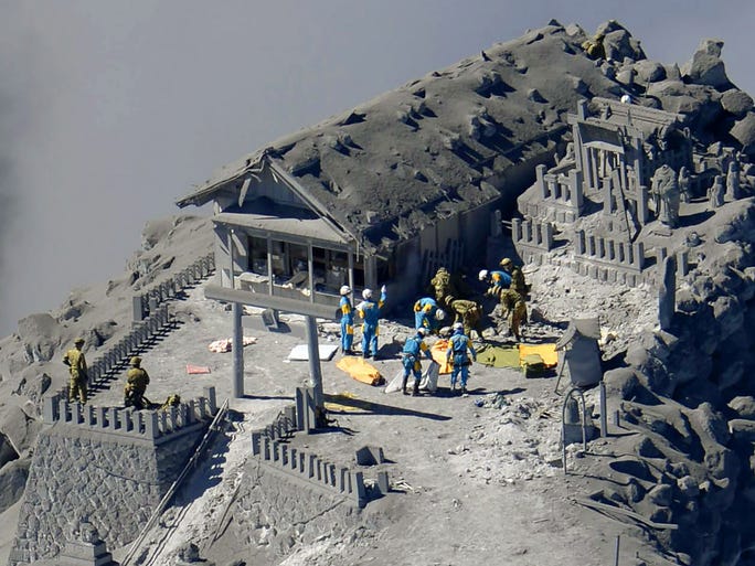 Rescue workers search buildings for missing people after Mt. Ontake sudenly erupted on Sept. 29 in Nagano, Japan. Thirty-one people died in the Sept. 28 eruption.