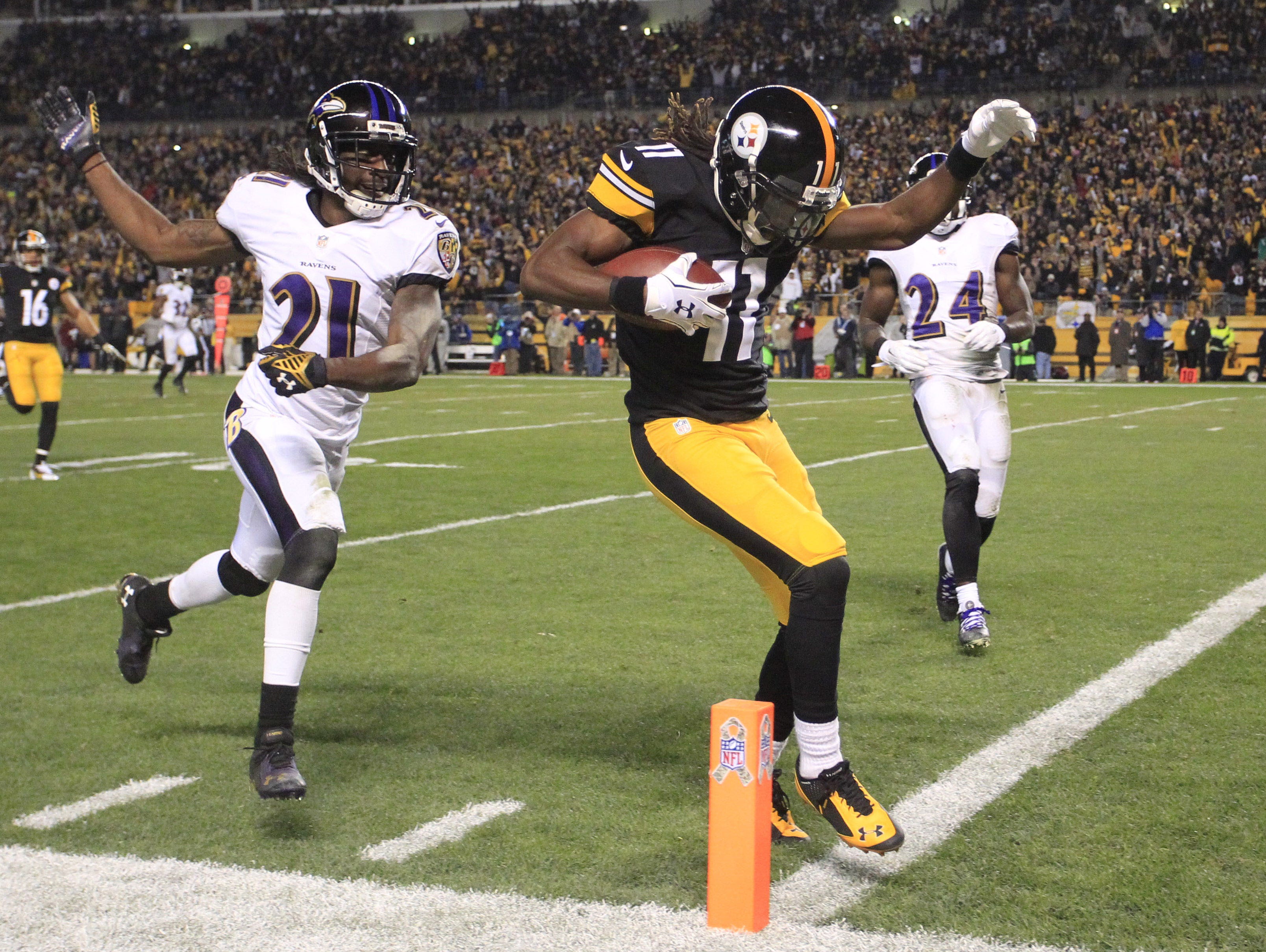 Pittsburgh Steelers wide receiver Markus Wheaton (11) scores on a 47-yard touchdown pass against Baltimore Ravens cornerback Lardarius Webb (21) during the second quarter at Heinz Field.