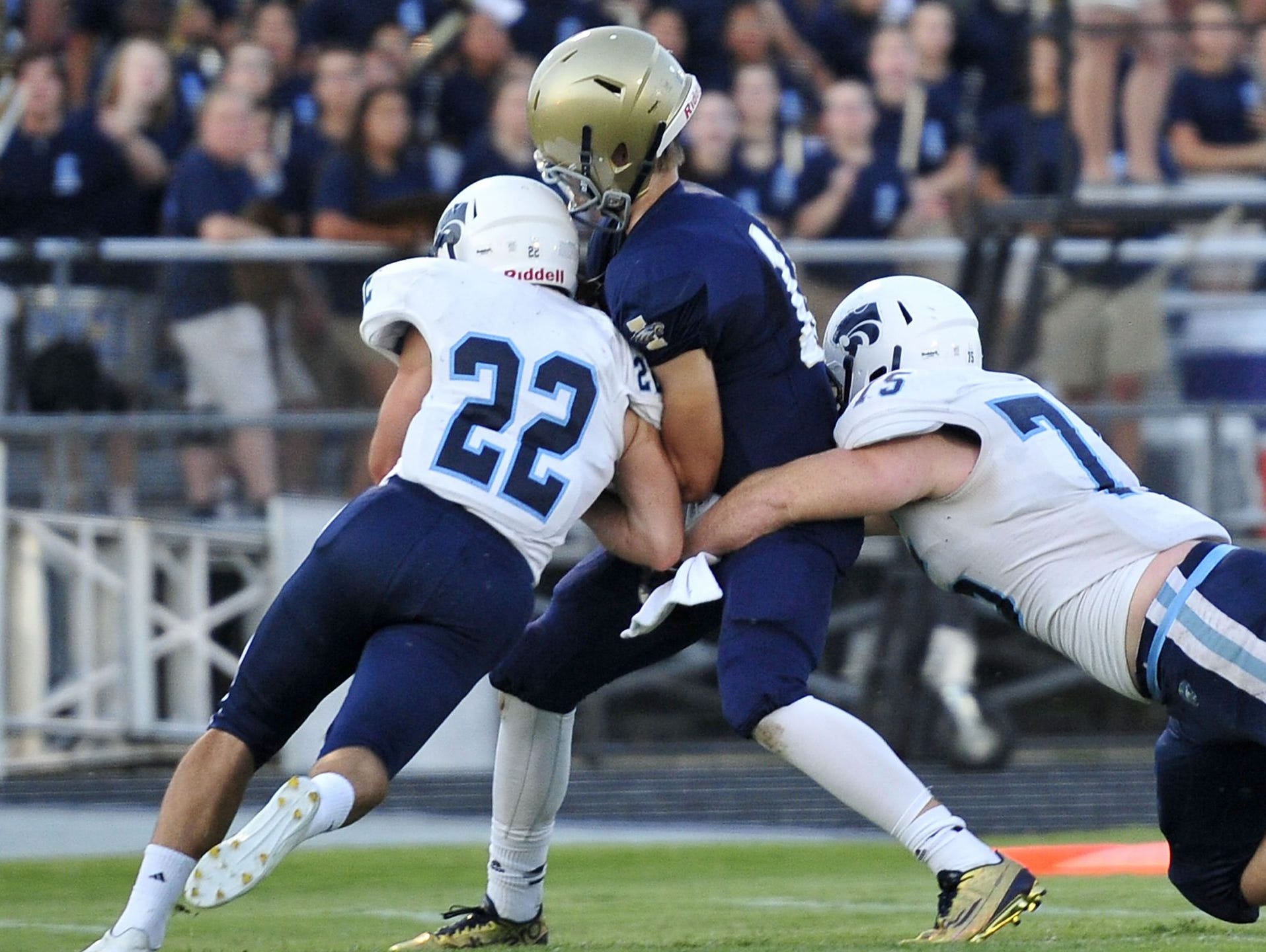 Centennial's Peyton Pisacane (22) and Greg Drewery bring down Independence's Andrew Bunch during the Cougars' Week 2 loss.