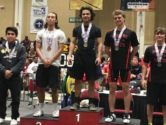 Pace High’s Adrian Acevedo stands proudly atop the medal stand after winning the 119-pound weight class at the Class 2A state meet. Acevedo benched 235 pounds and cleaned 225 pounds to finish with a total of 460 pounds.