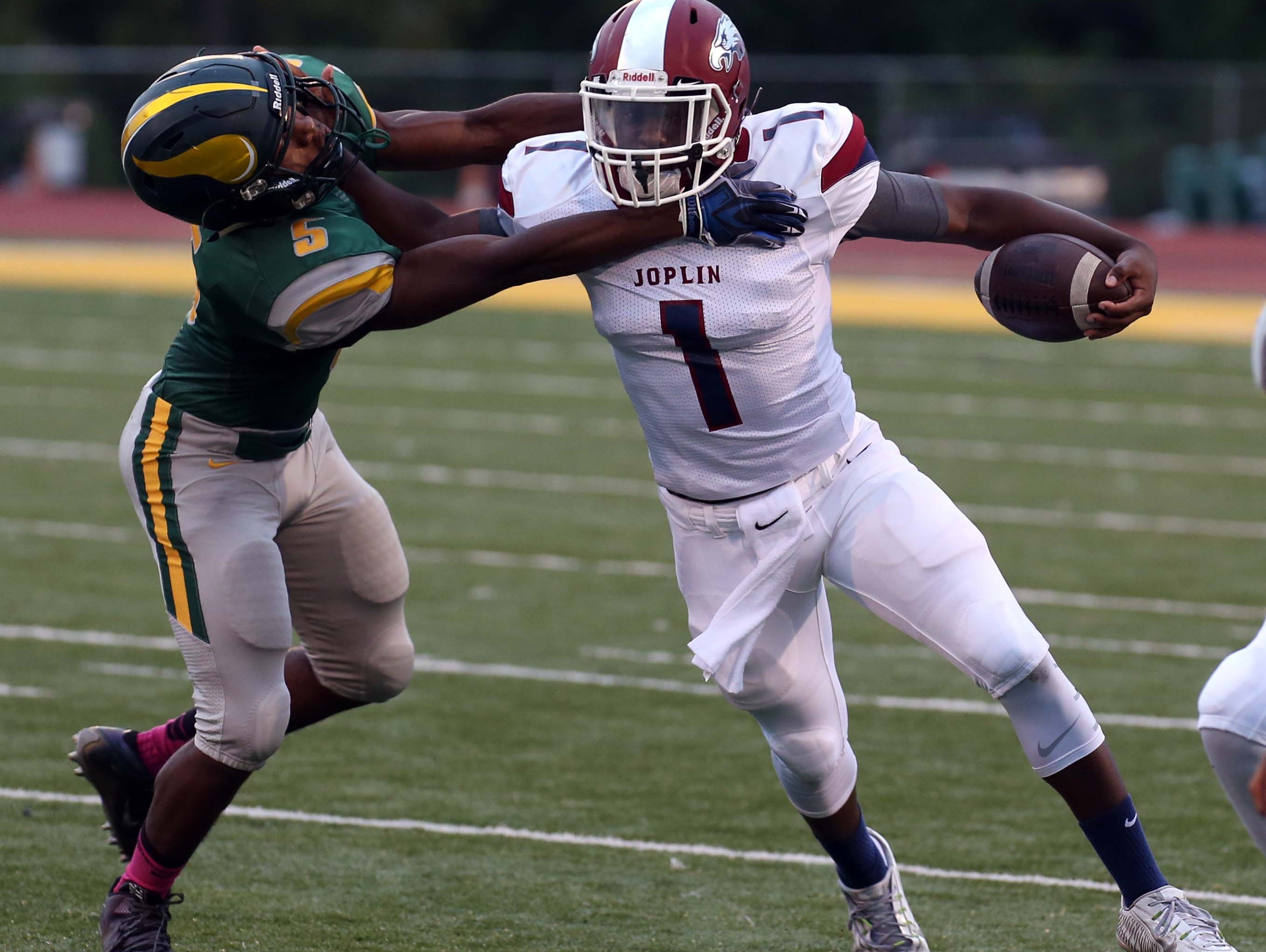Joplin quarterback Jokiem Crawford fights off CJ Loveall of Parkview in Springfield on August 26, 2016.