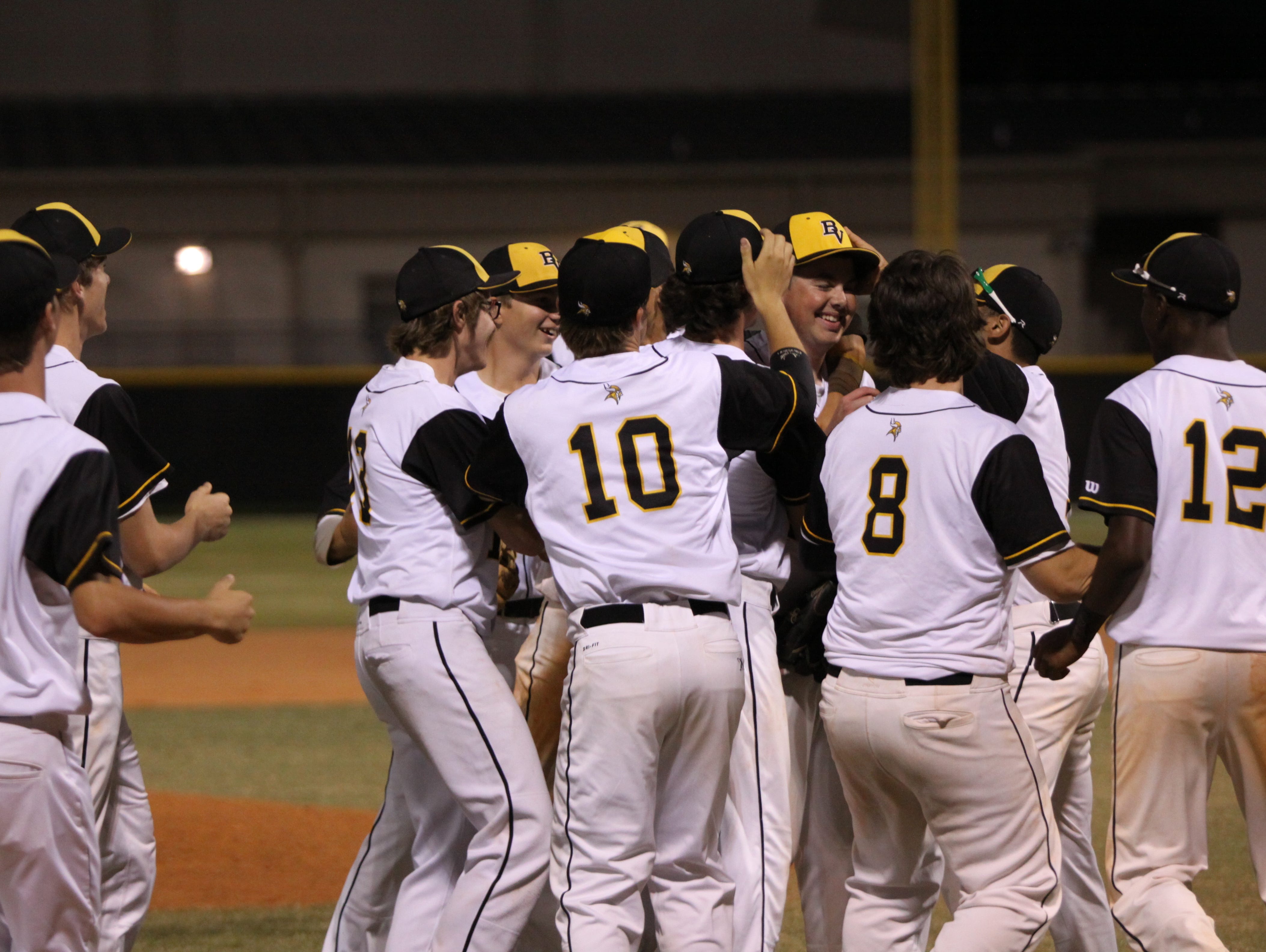 The Bishop Verot baseball team mobs senior Jaret Rusnell after he finishes off the final two outs of the team's game on April 7.