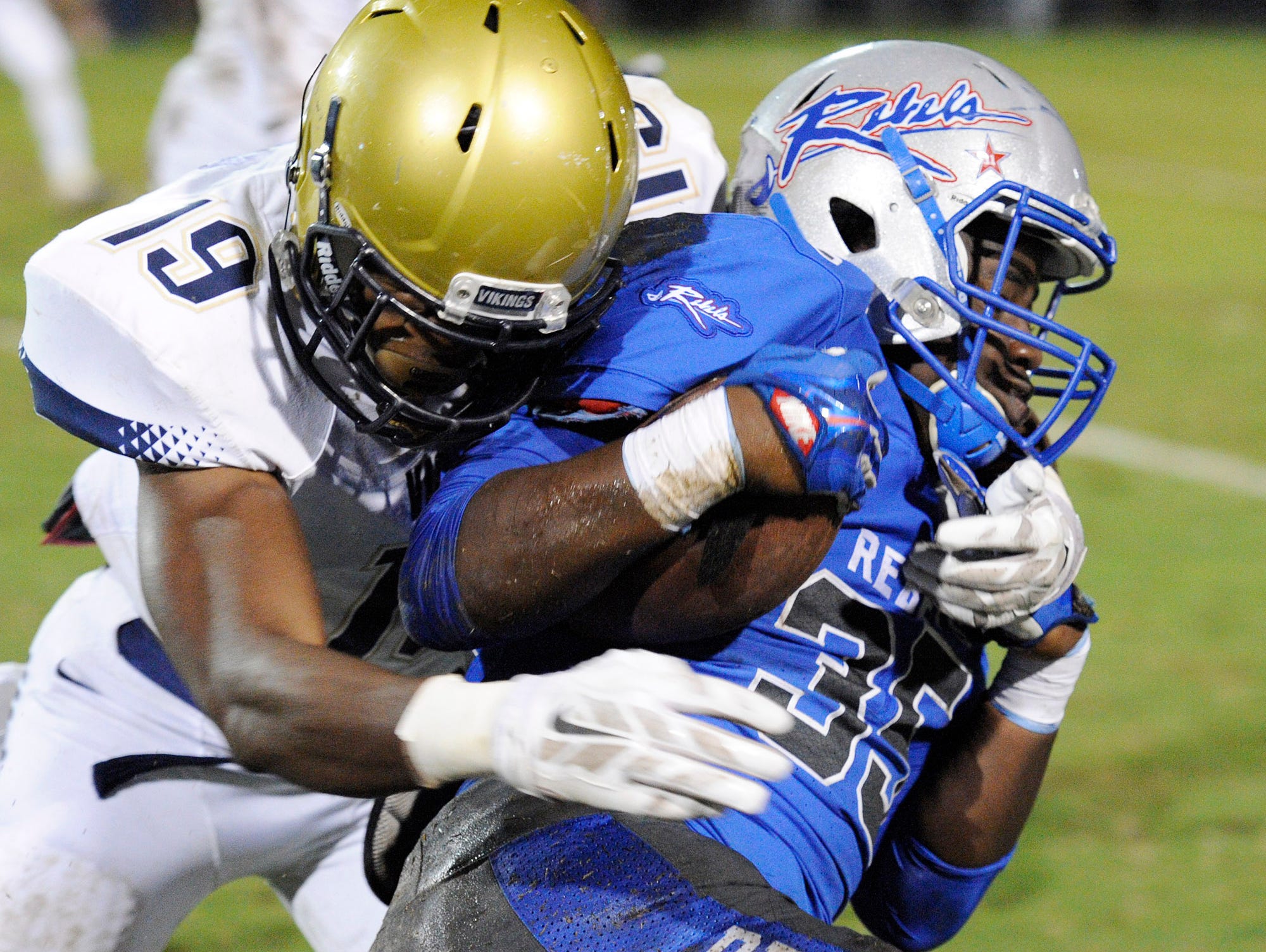 Byrnes running back Quez Mayes (35) is stopped by Spartanburg's Mike Murphy (19).