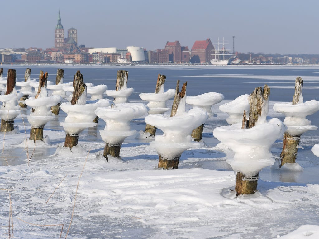 Bizarre structures of ice surround breakwaters on the small Baltic Sea island of Daenholm as in background can be seen the skyline of Stralsund, northeastern Germany on March 4, 2018