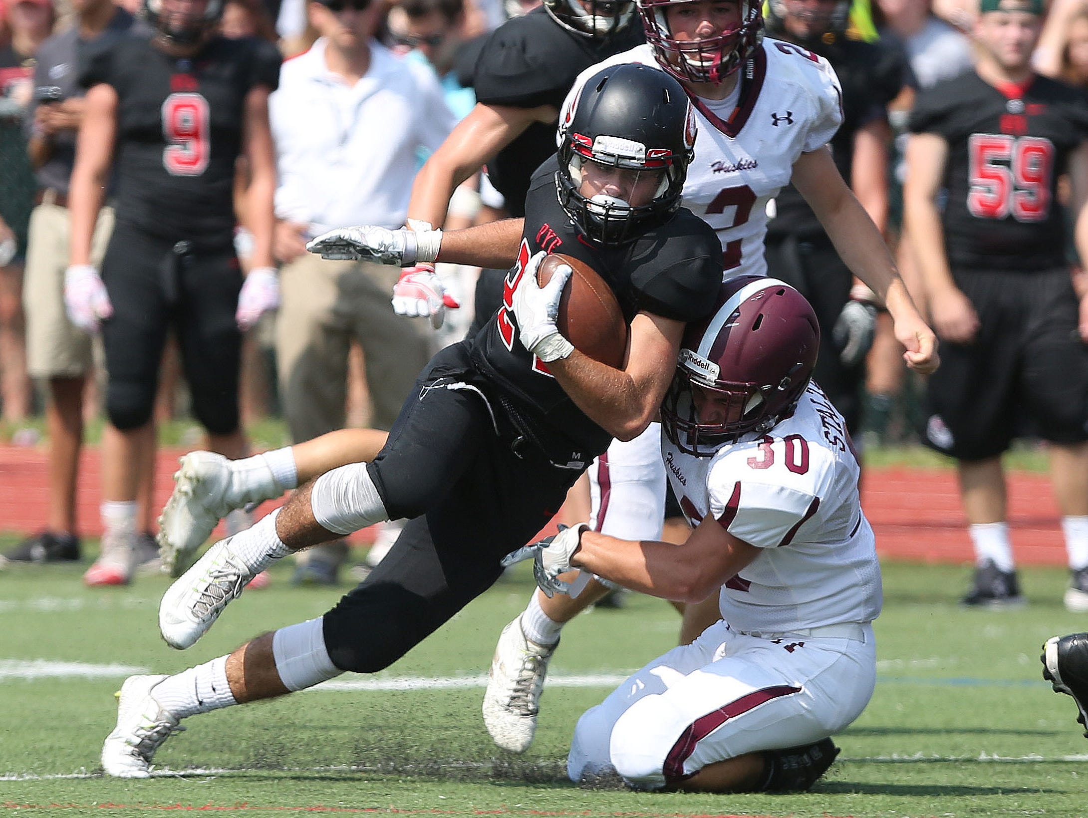 Rye's James Chabot (24) tries to get around Harrison's Kyle Stalteri (30) during first half action in the annual rivalry game at Nugent Stadium at Rye High School Sept. 10, 2016. Rye won the game 42-12.