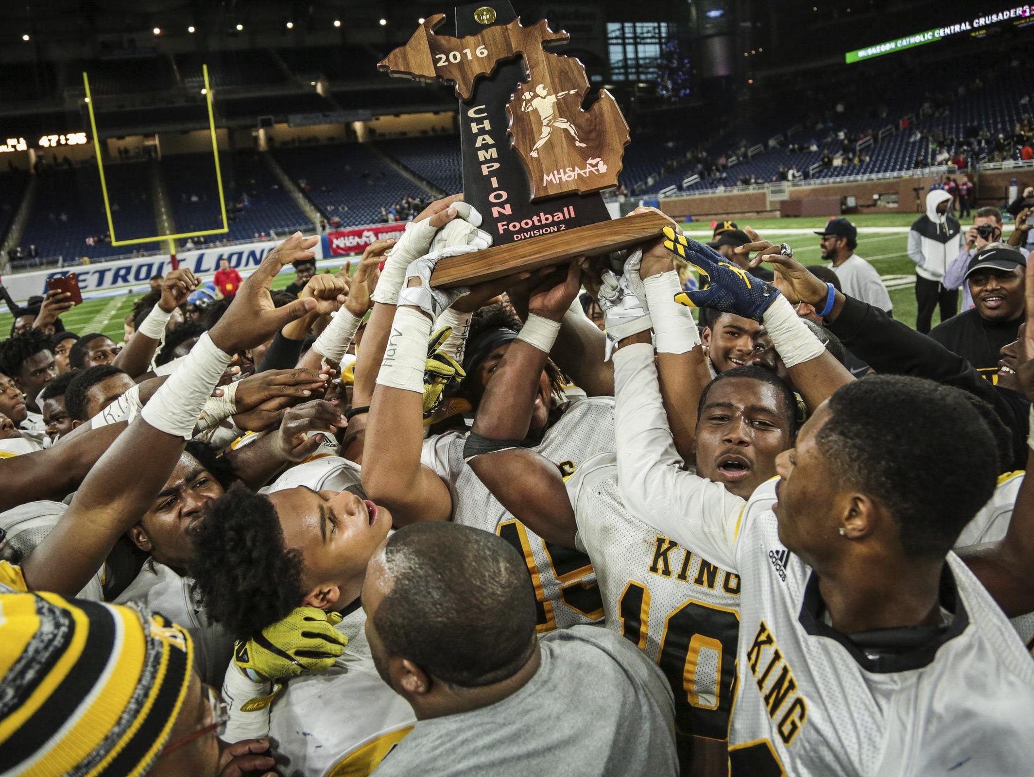Detroit King players celebrate winning the title against Walled Lake Western during the Division 2 title game Friday.