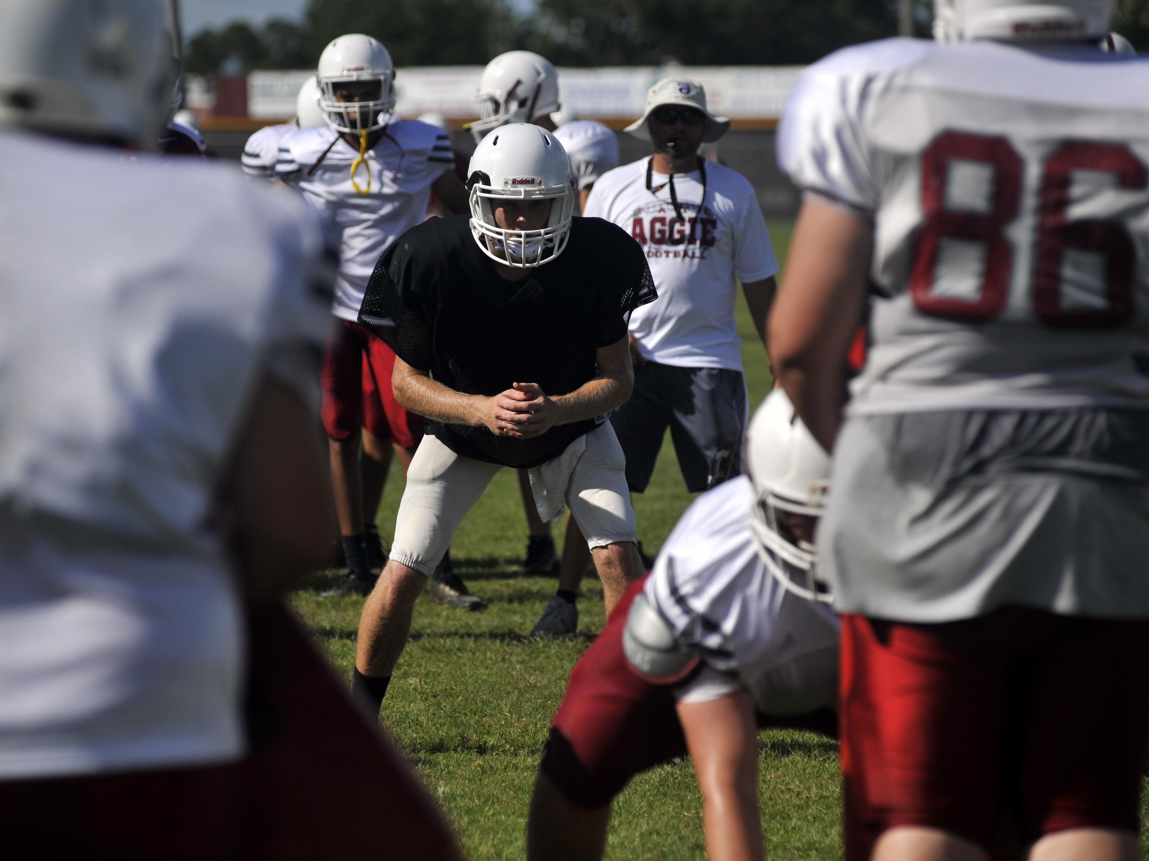 Tate quarterback Jake Henry prepares to receive a snap while head coach Jay Lindsey looks on during practice on Aug. 16, 2016.