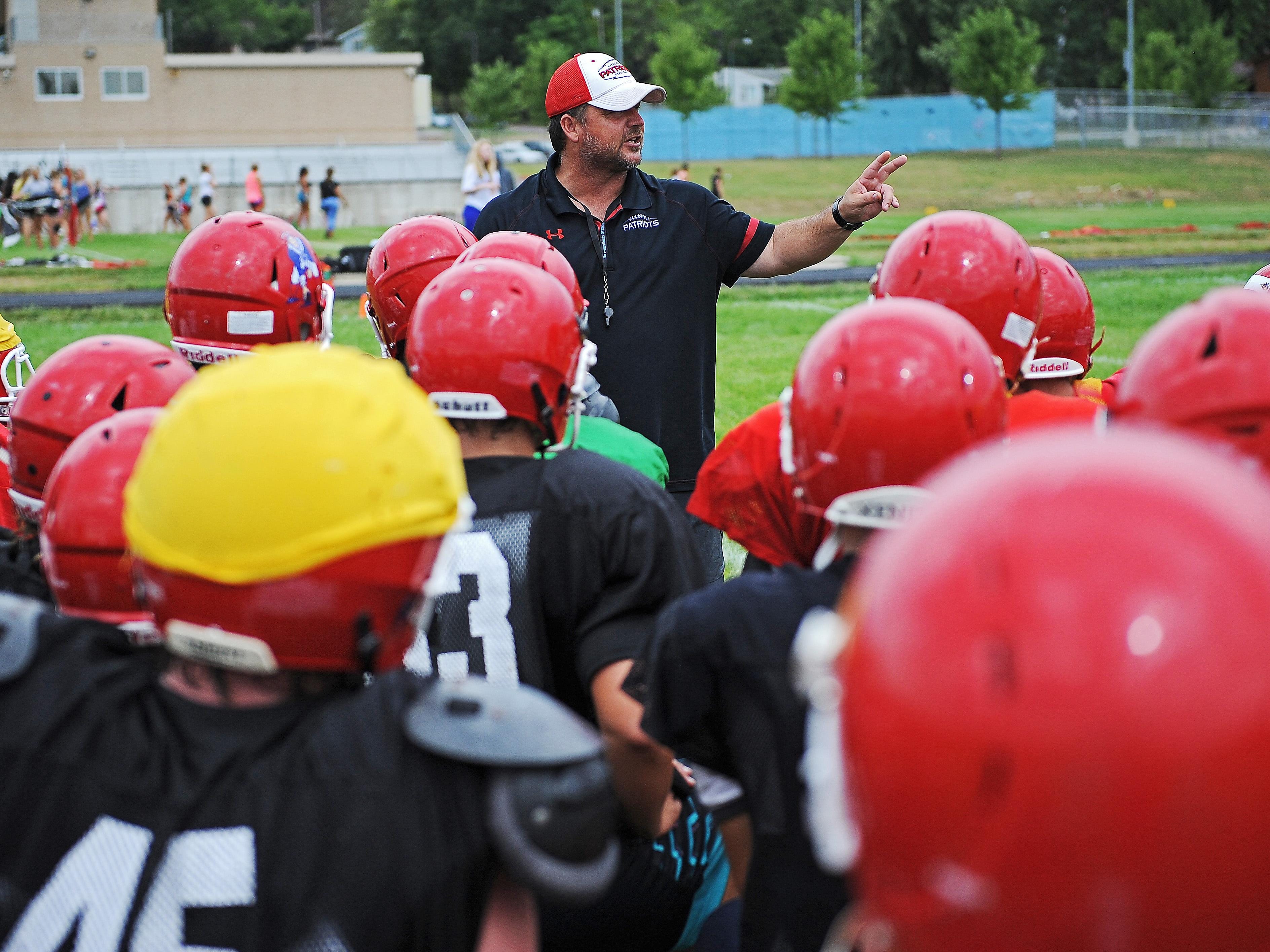 Lincoln High School football coach Aaron Beavers speaks to his team during a Lincoln High School football practice Thursday, Aug. 11, 2016, at Lincoln High School in Sioux Falls.