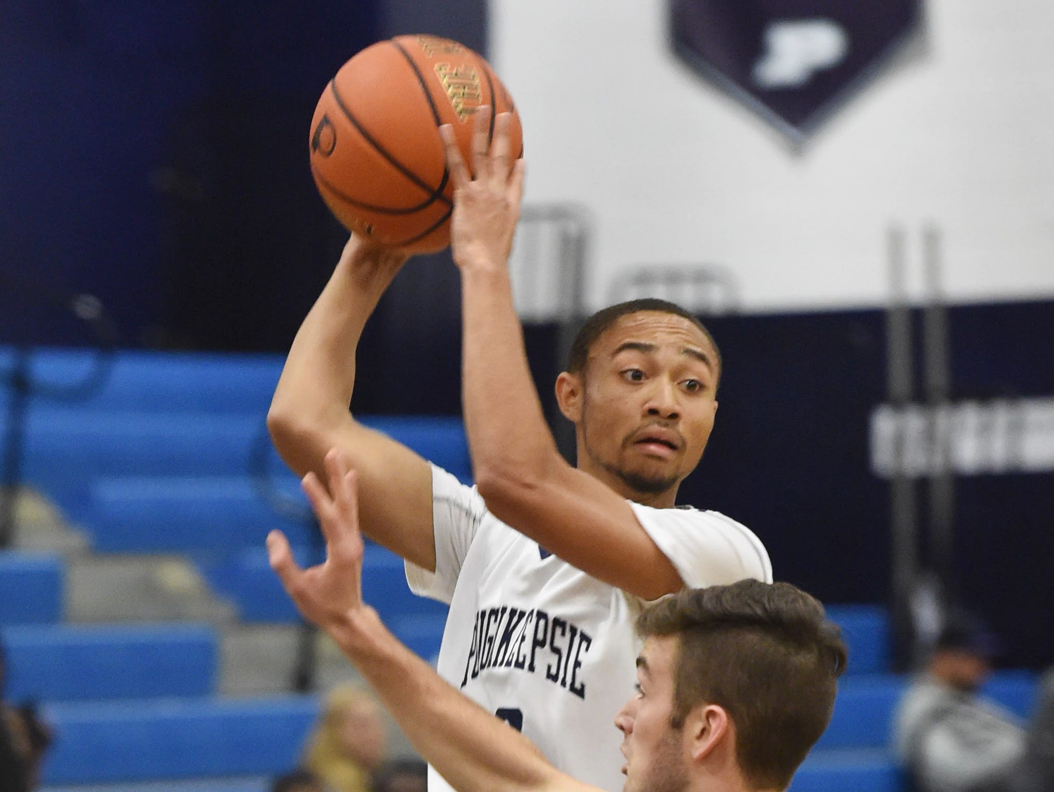 Poughkeepsie High School's Troy Schoonmaker looks for a teammate to pass the ball to as Franklin D. Roosevelt's James McKenna covers him during a Dec. 11 game at Poughkeepsie High School.