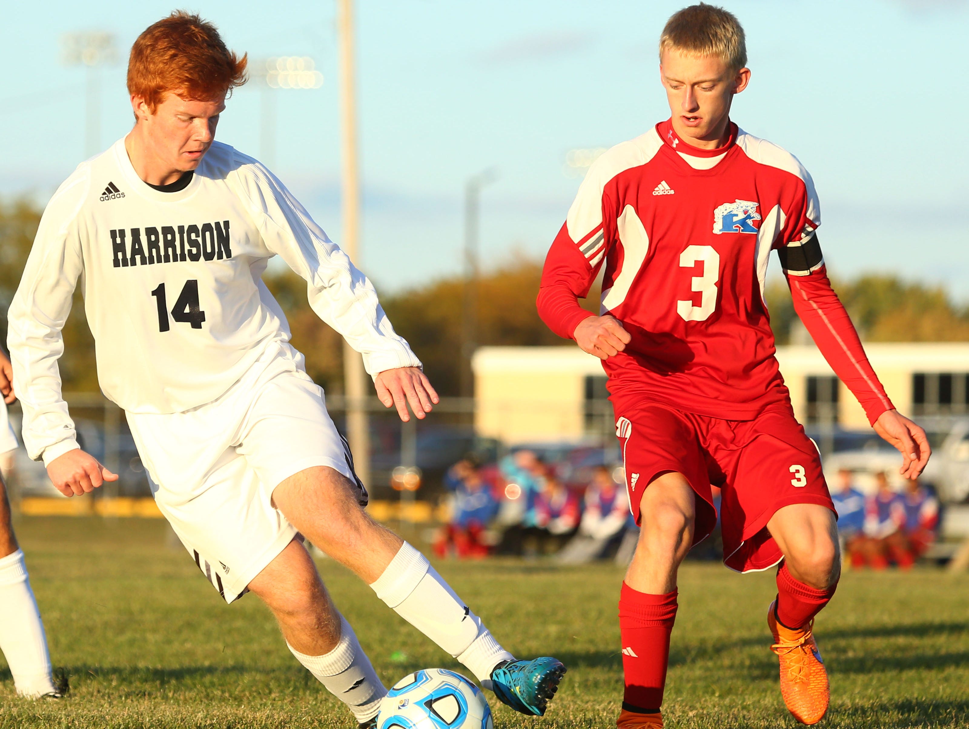 Harrison's Jeremy Dewell keeps the ball away from Kokomo's Keagan James.