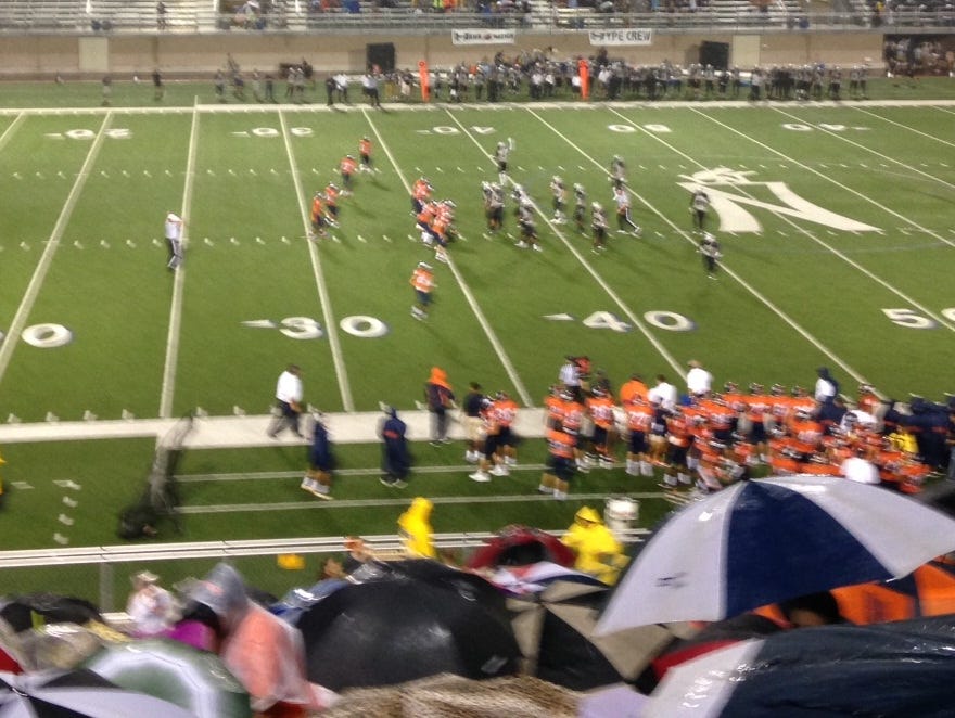 Fans stay dry during a Brandeis High School football game.