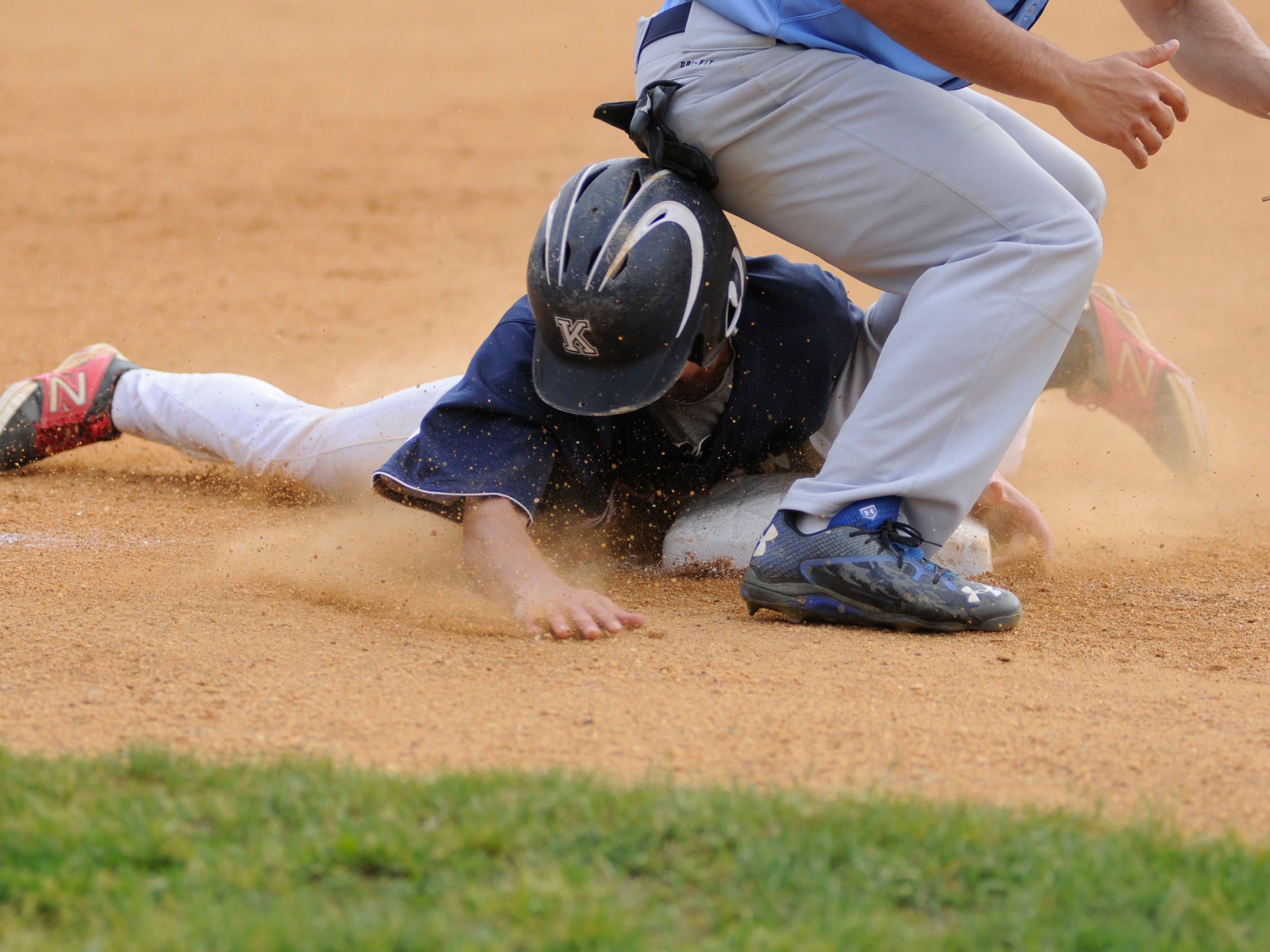 Roy C. Ketcham High School's Matt Lynch slides into third base while John Jay High School's Peter DiMeglio waits for the throw.