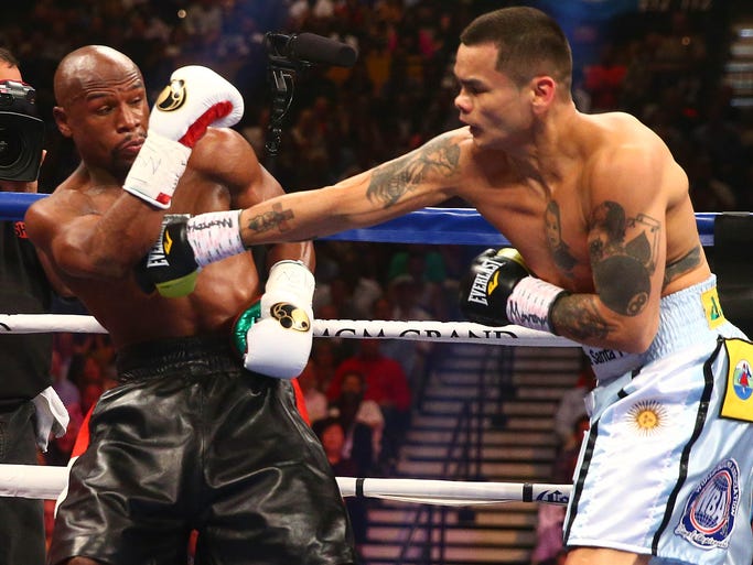 Marcos Maidana punches as Floyd Mayweather Jr. defends during their fight at MGM Grand.