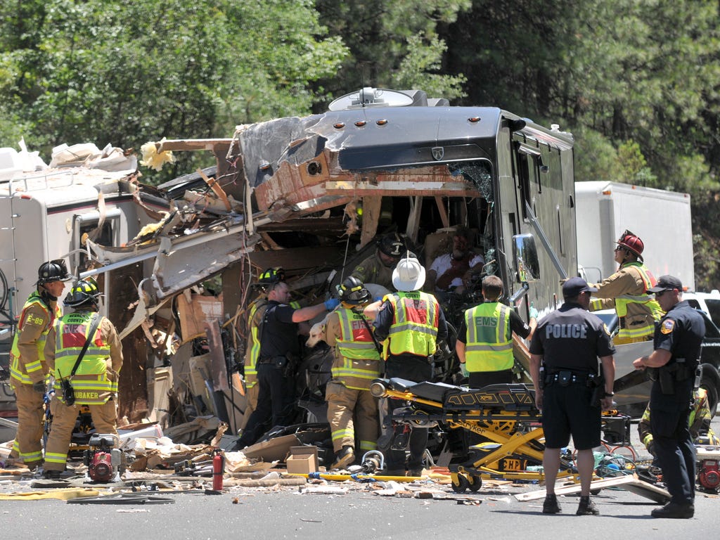 Firefighters, paramedics, and CHP officers work to extricate a dog and the driver of one of the RV's involved in a head on collision on Highway 49 near the Golden Chain Motel in Grass Valley, Calif.