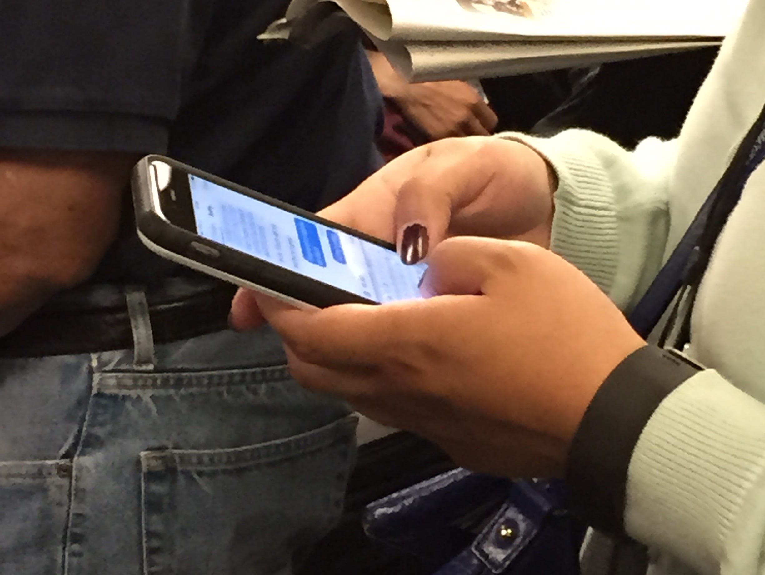 A rider texting on a BART train in San Francisco.