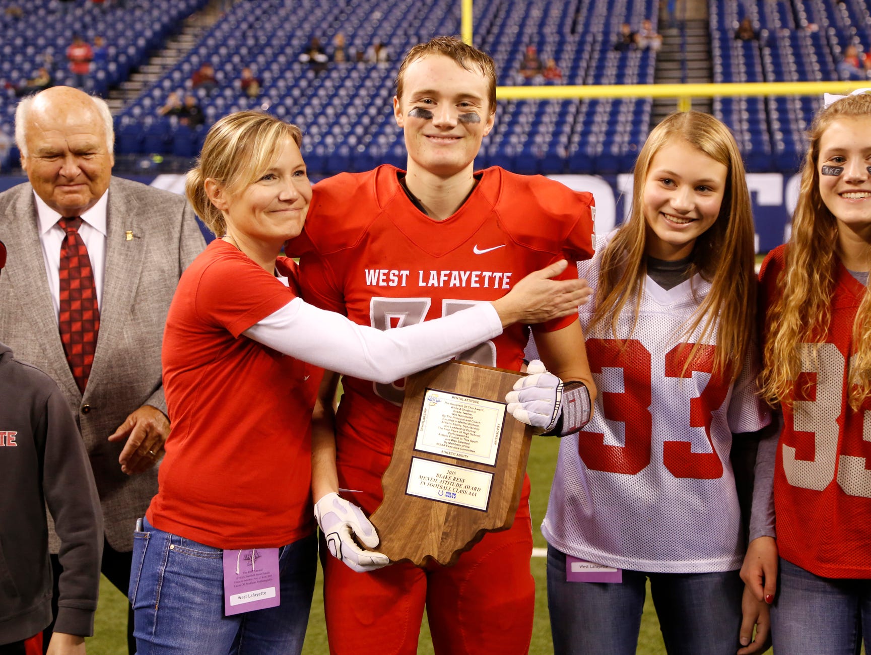 West Lafayette's Jack Folkers is embraced by his mother, Brooke Folkers, after he received the Mental Attitude Award following the Red Devils game against Bishop Chatard in the Class 3A state finals Friday, November 27, 2015, at Lucas Oil Stadium in Indianapolis. West Lafayette fell to Bishop Chatard 31-7.