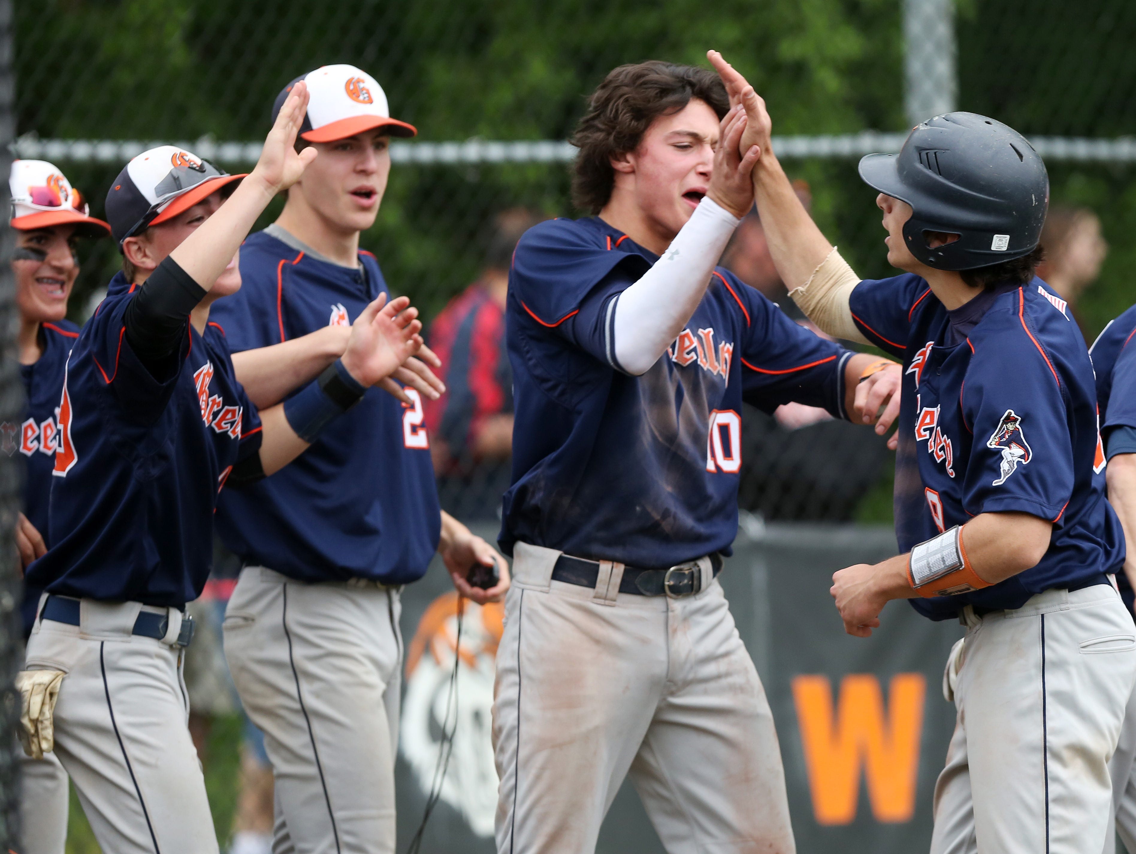 Horace Greeley's Nate Goodman, right, celebrates with teammates after scoring on Brandon Neeck's second-inning single against White Plains during a Section 1 playoff game at White Plains High School Saturday.
