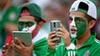 Mexican team fans record the festivities as the game