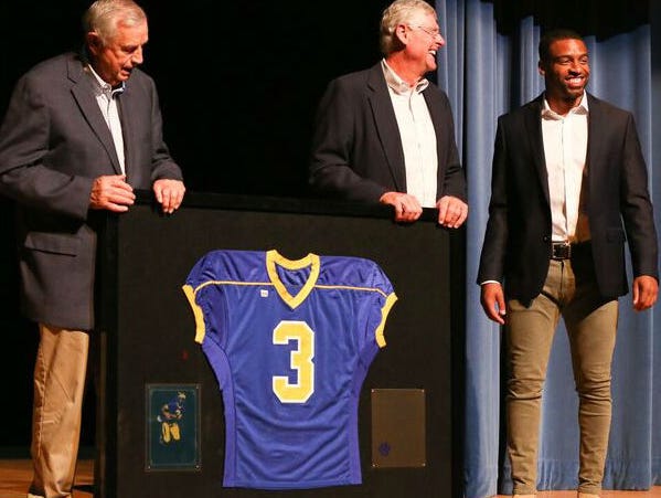 Former Goodpasture quarterback Keenan Reynolds, right, is presented with his retired jersey No. 3 by Goodpasture athletics director Clint Parnell, left, and former coach David Martin.