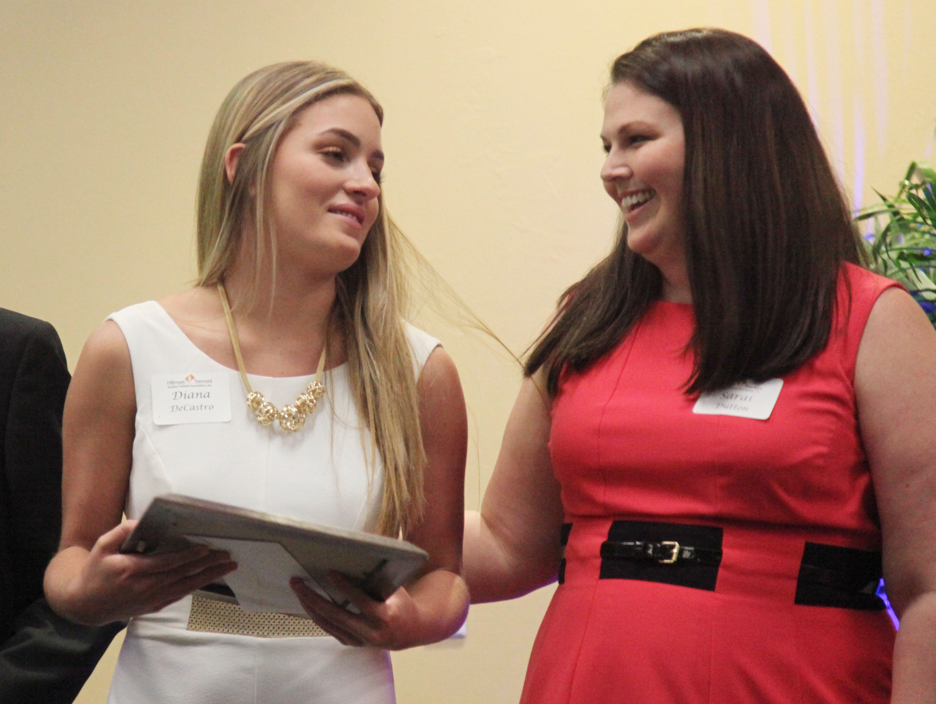 Diana DeCastro, of South Fort Myers High School is congratulated by coach Sarai Dutton during the Hillmyer-Tremont scholarship banquet at FGCU’s Cohen Center on Monday.
