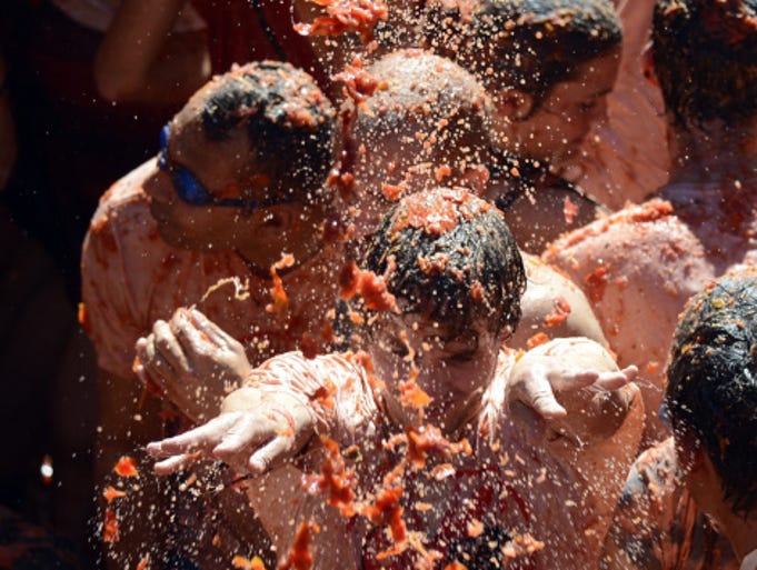 VALENCIA, SPAIN - AUGUST 27: Revellers throw tomatoes while participating the annual La Tomatina festival on August 27, 2014 in Bunol district of Valencia, Spain. (Photo by Evrim Aydin/Anadolu Agency/Getty Images)