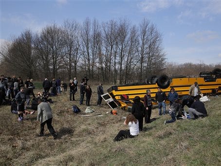 People on the scene of a school bus accident attend to the injured after the bus carrying Griffith High boys basketball team overturned in Demotte, Ind., Saturday, March 19, 2016. The bus rolled over on Interstate 65 on the way to Saturday's semifinal game against Marion at Lafayette Jefferson.