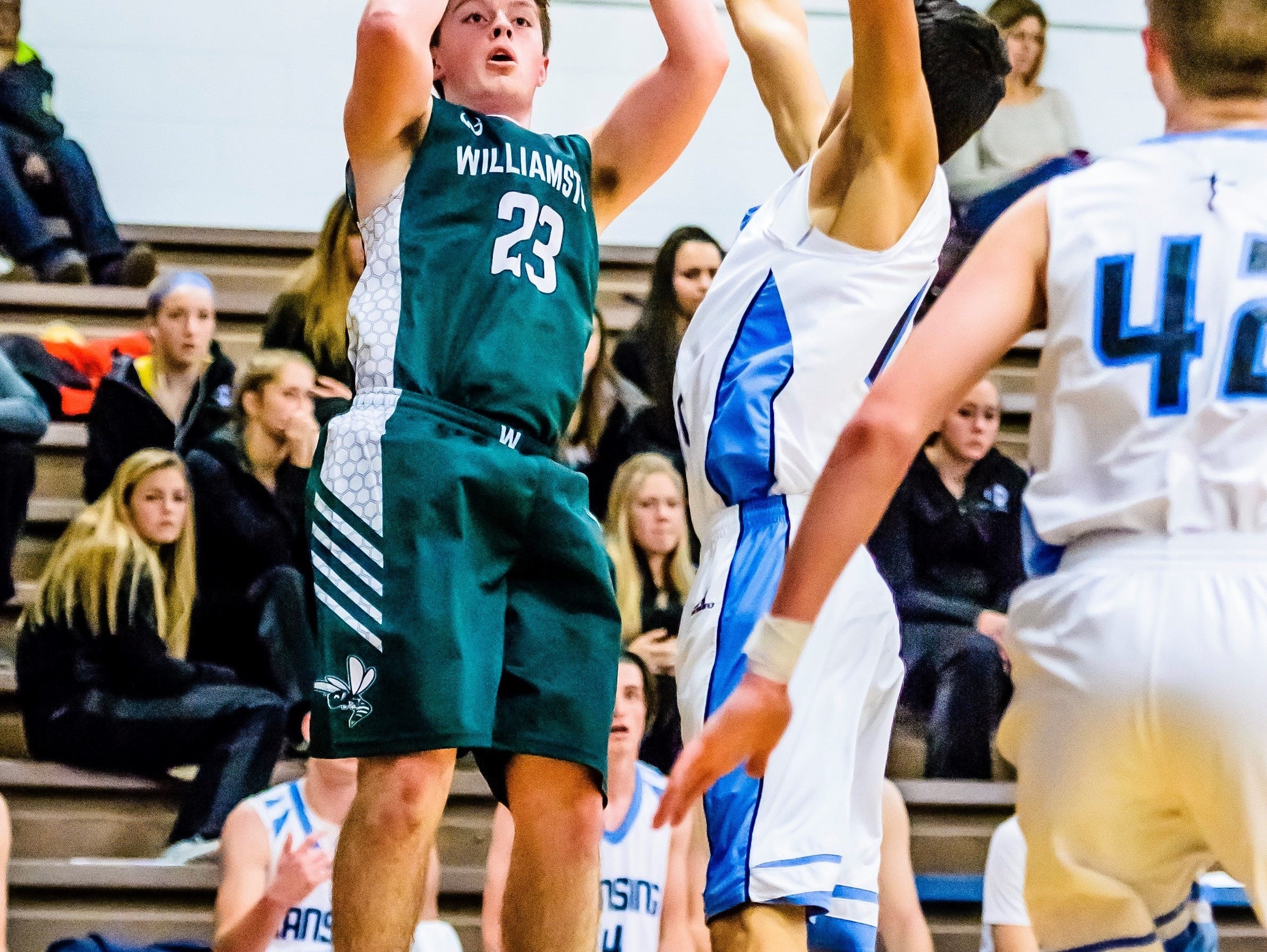 Cole Kleiver, 23, of Williamston knocks down a 3-point shot over a Lansing Catholic defender during its game Friday, December 9, 2016, in Lansing.