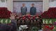 A North Korean portrait photographer instructs soldiers to pose for a picture under a mosaic of the late leaders Kim Il Sung and Kim Jong Il at an exhibition in Pyongyang on Feb. 17, where Kimjongilia flowers, named after Kim Jong Il, were on display.